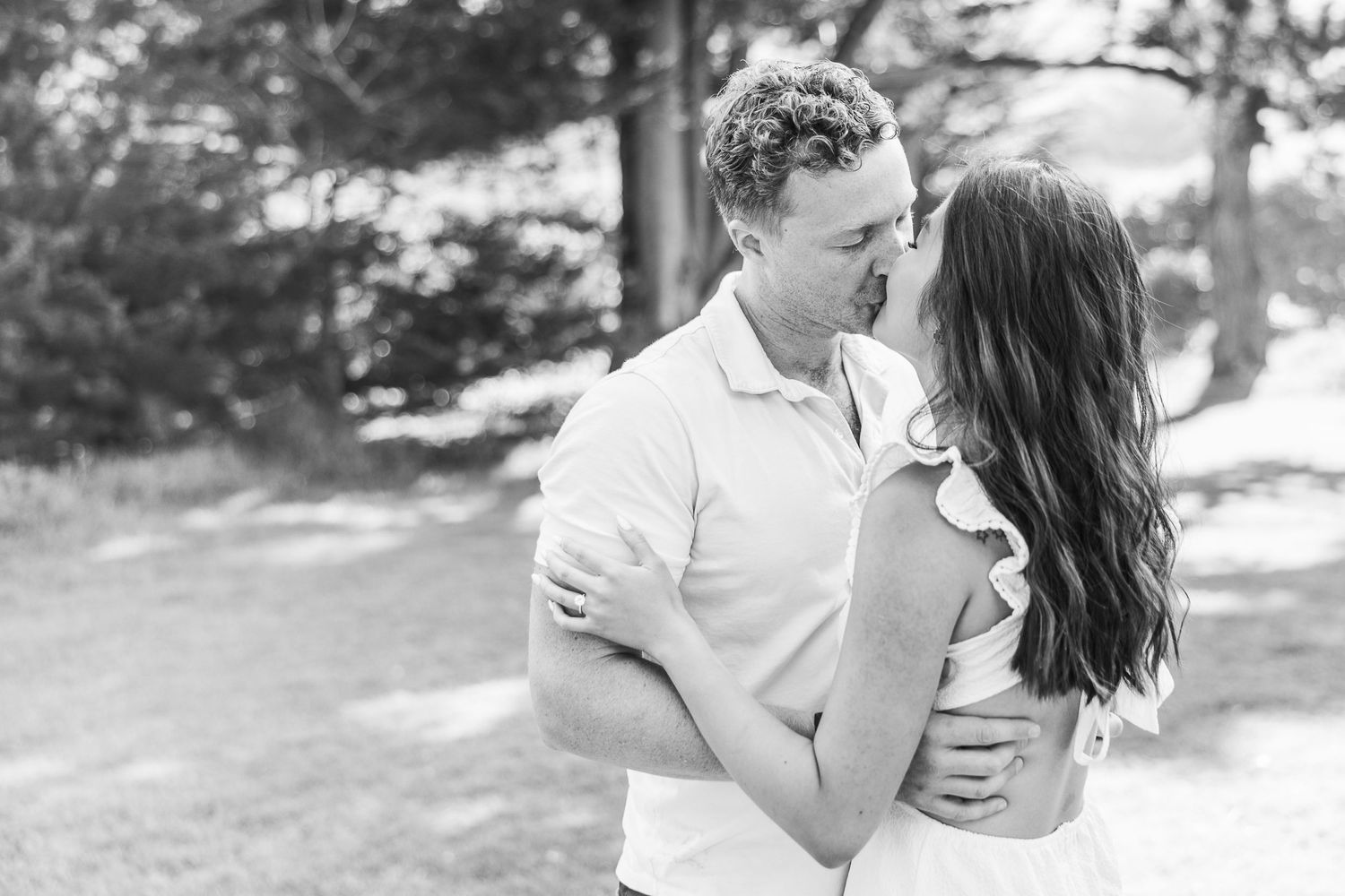 Black and white photo of a couple in a tender embrace outdoors.