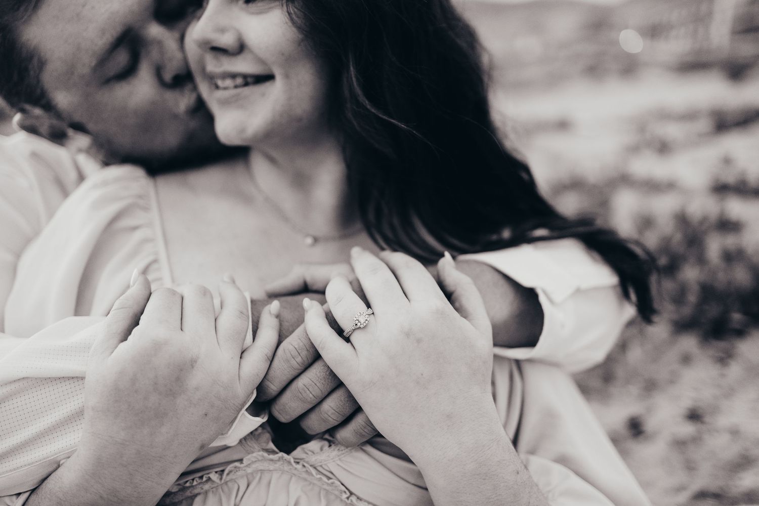Black and white close-up of embracing hands showing intimate connection.