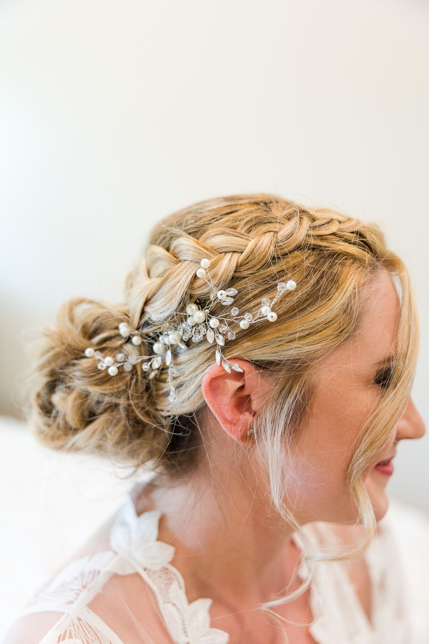 Elegant bridal hairstyle with pearl and crystal hair accessories in an updo style.