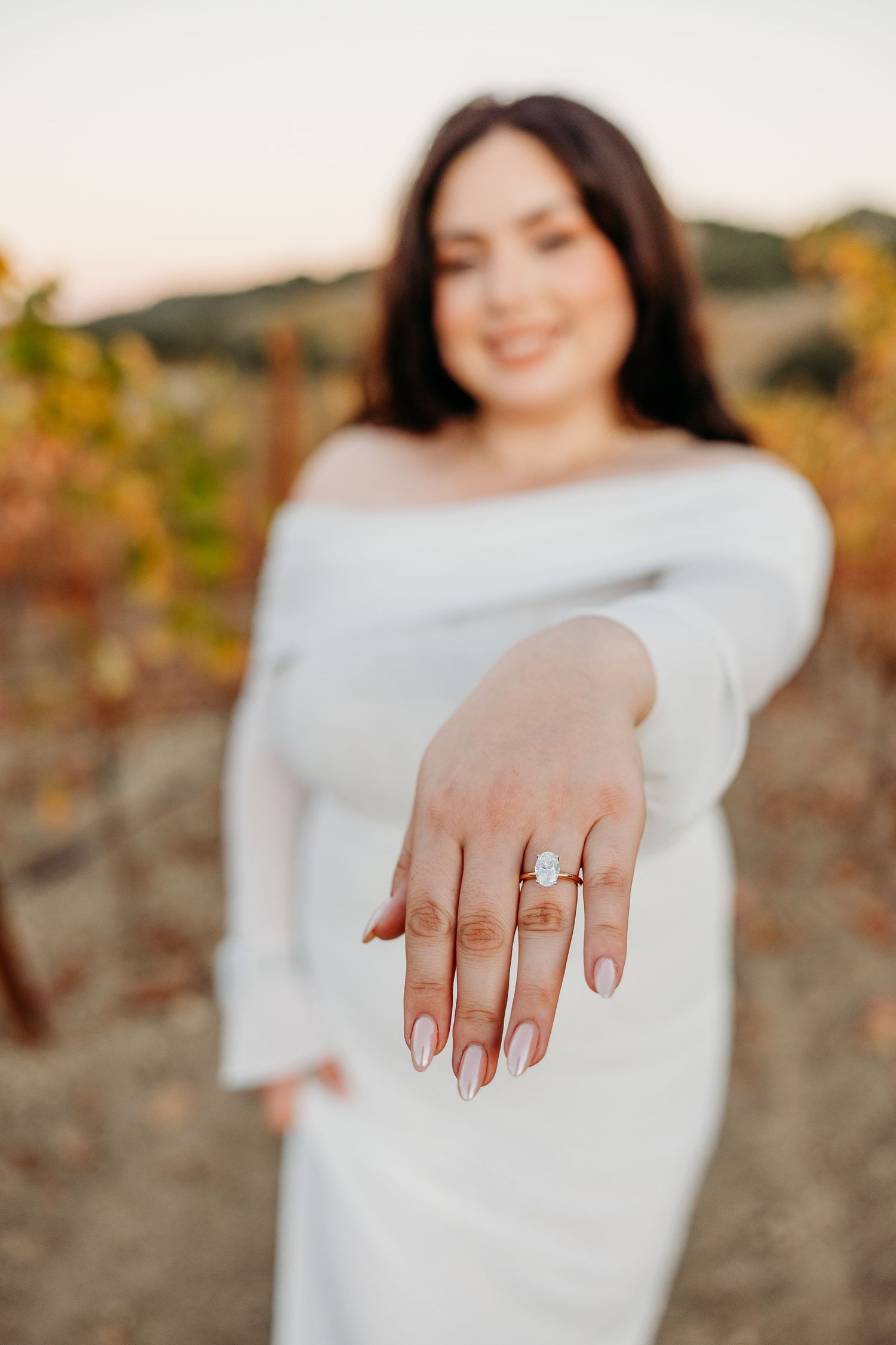 Close-up shots of an engagement ring being displayed on a woman's hand with autumn vineyard scenery in background.
