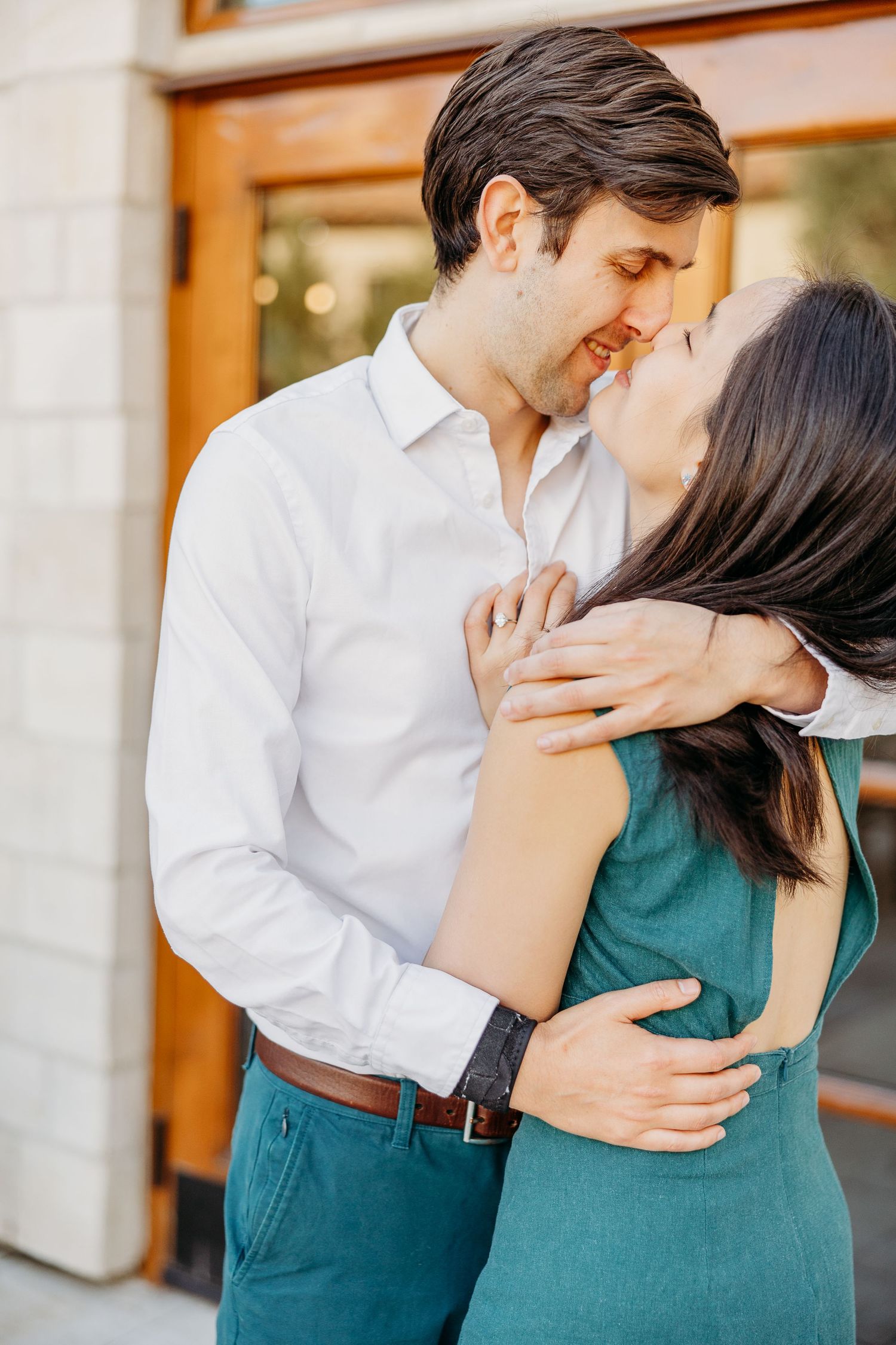A couple in white shirt and teal dress share intimate moments in a romantic outdoor photoshoot sequence.