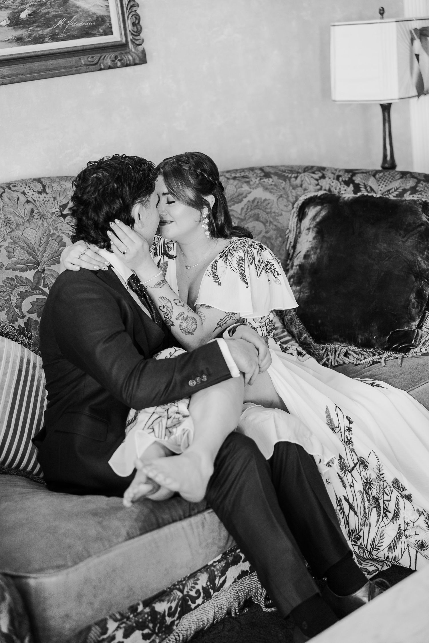 Black and white photo of a romantic moment on a patterned couch.