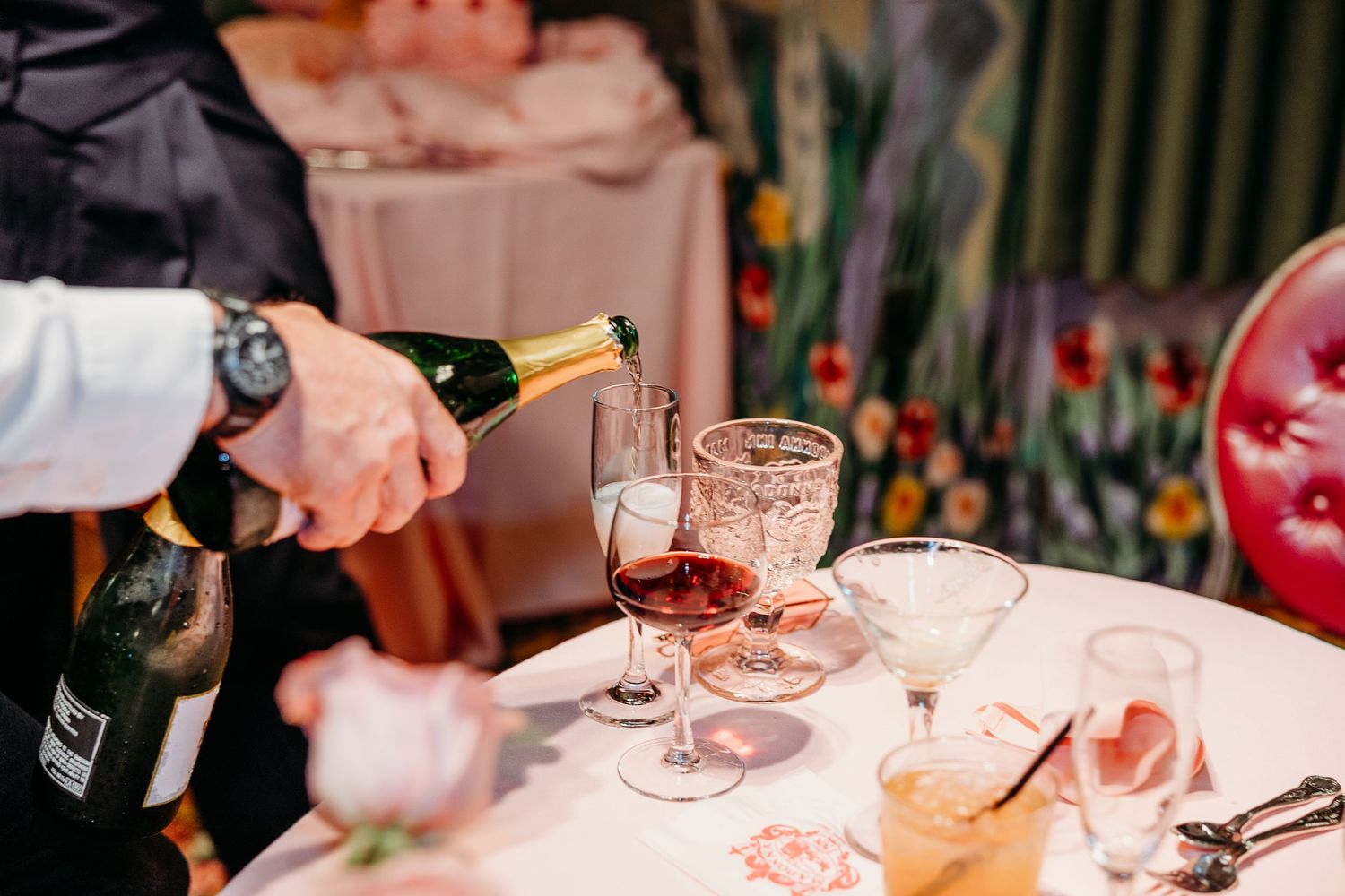 Champagne being poured into glasses at an elegant wedding reception table.