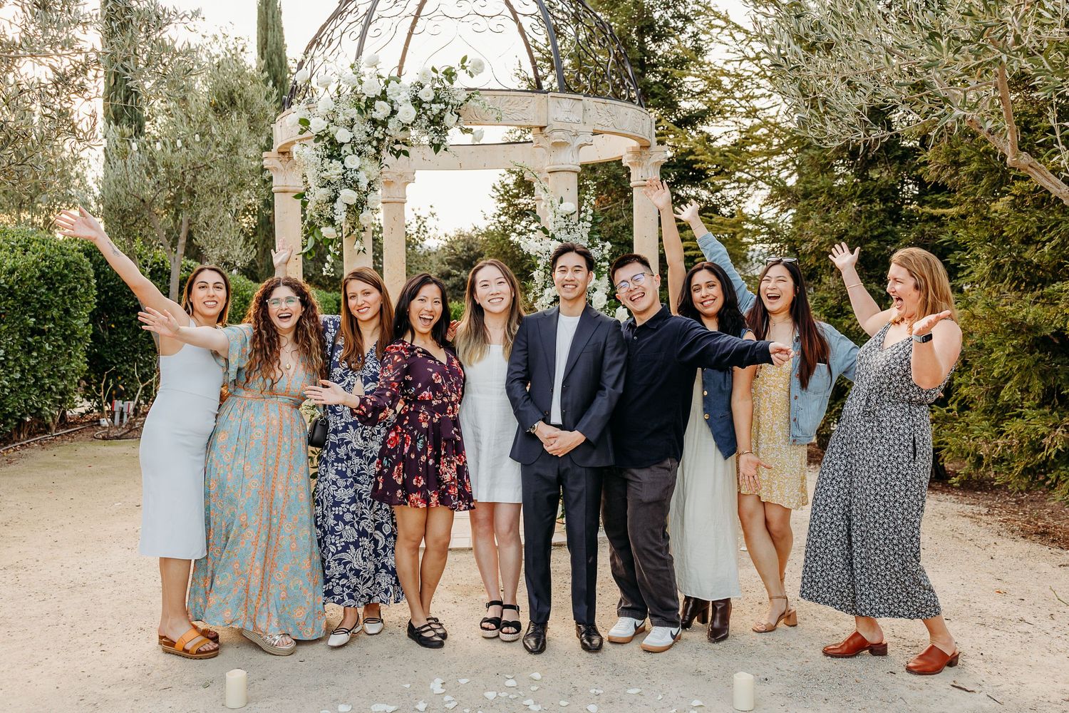 A cheerful group celebrates together under a white garden pergola during sunset in Paso Robles