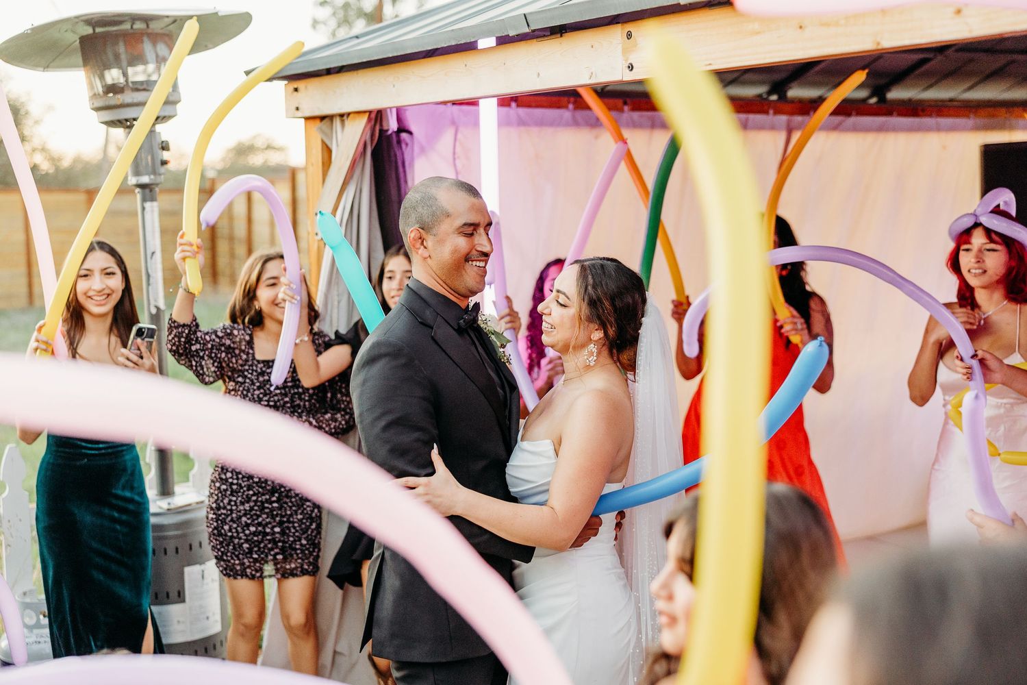 Festive wedding reception celebration with colorful decorations and dancing guests.