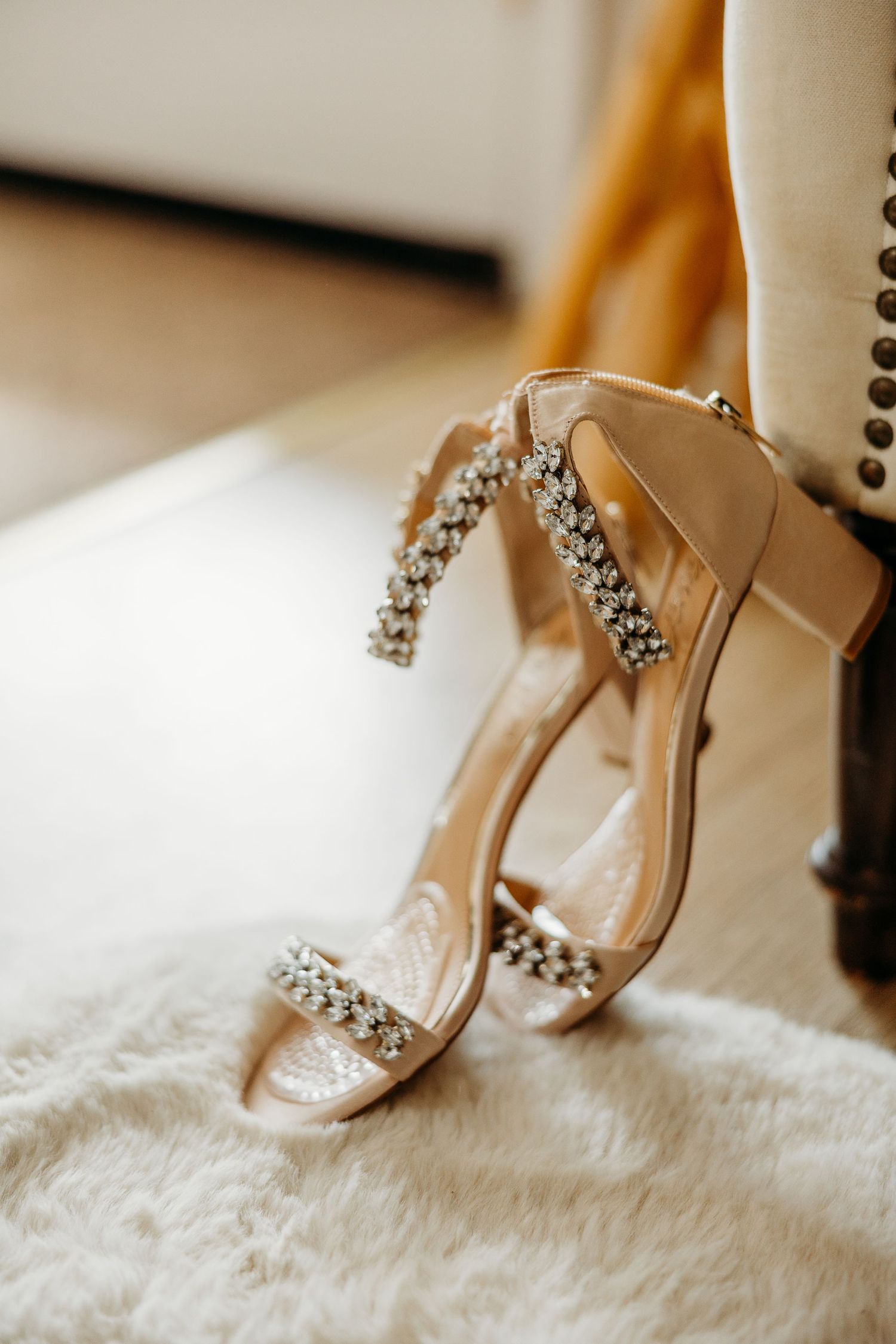 Elegant bridal sandals with crystal embellishments resting on white fur fabric.