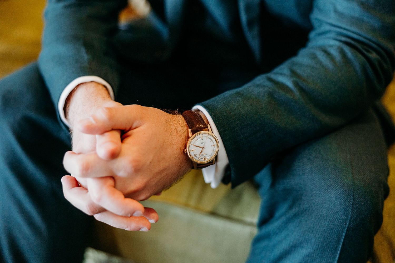 Multiple hands in formal attire reach towards the center in a group gesture during a special event.