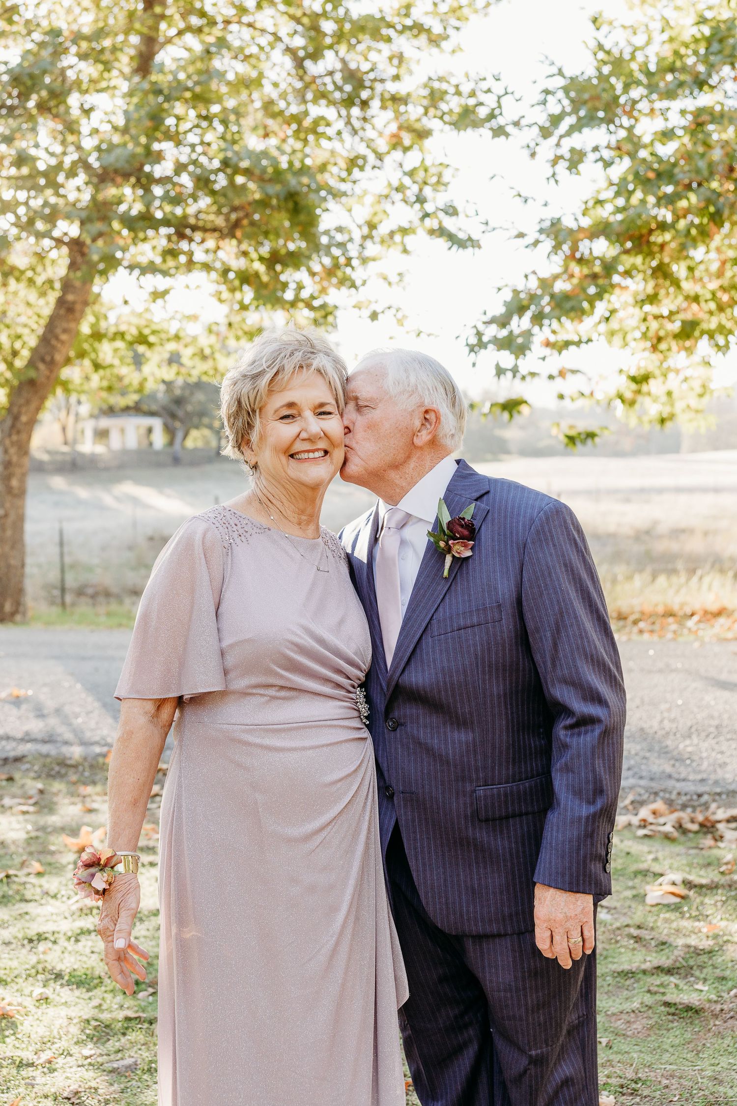 Couple sharing a tender moment during their wedding celebration in an outdoor autumn setting.