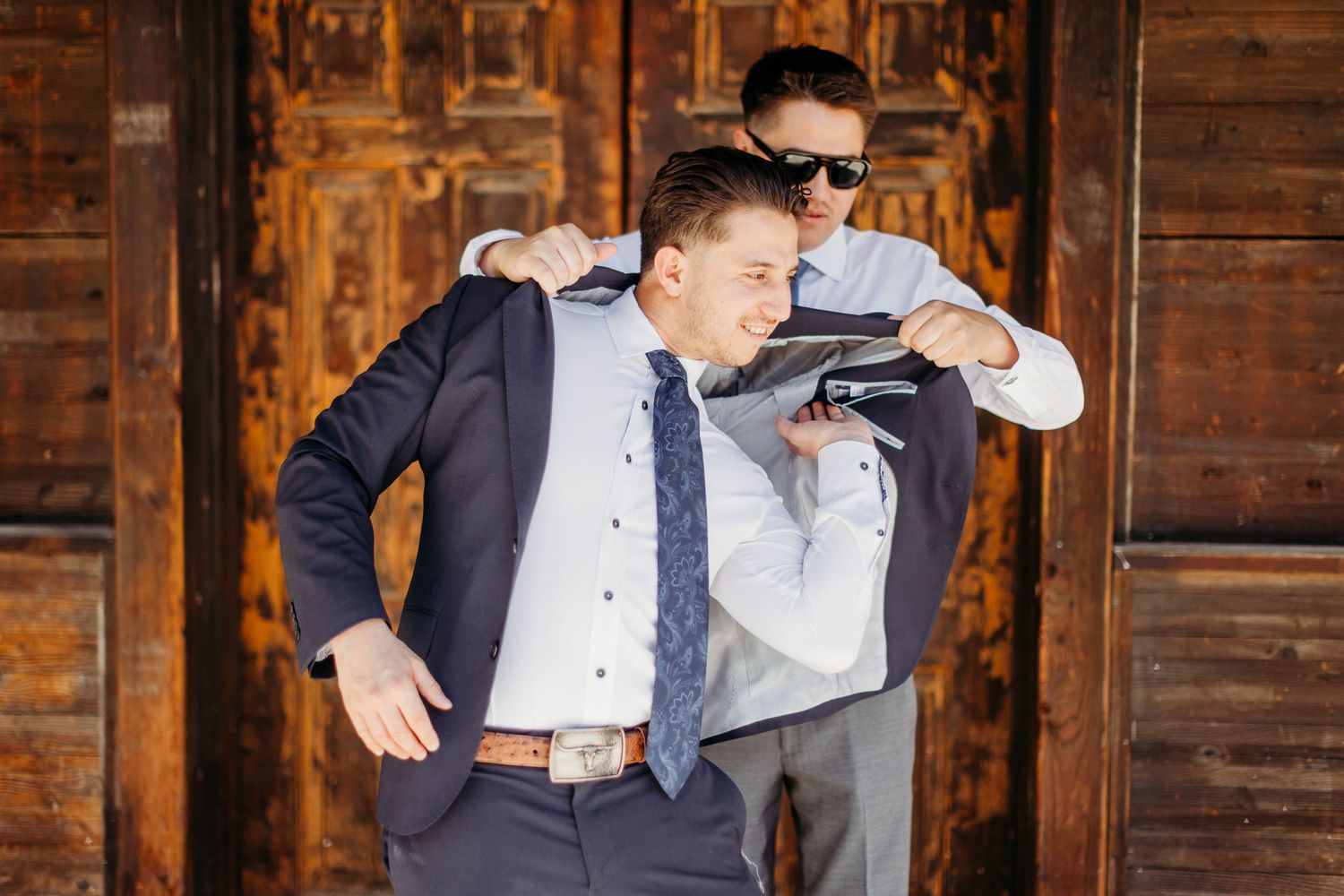 Wedding guests dancing and celebrating at a rustic wooden barn venue with warm lighting.