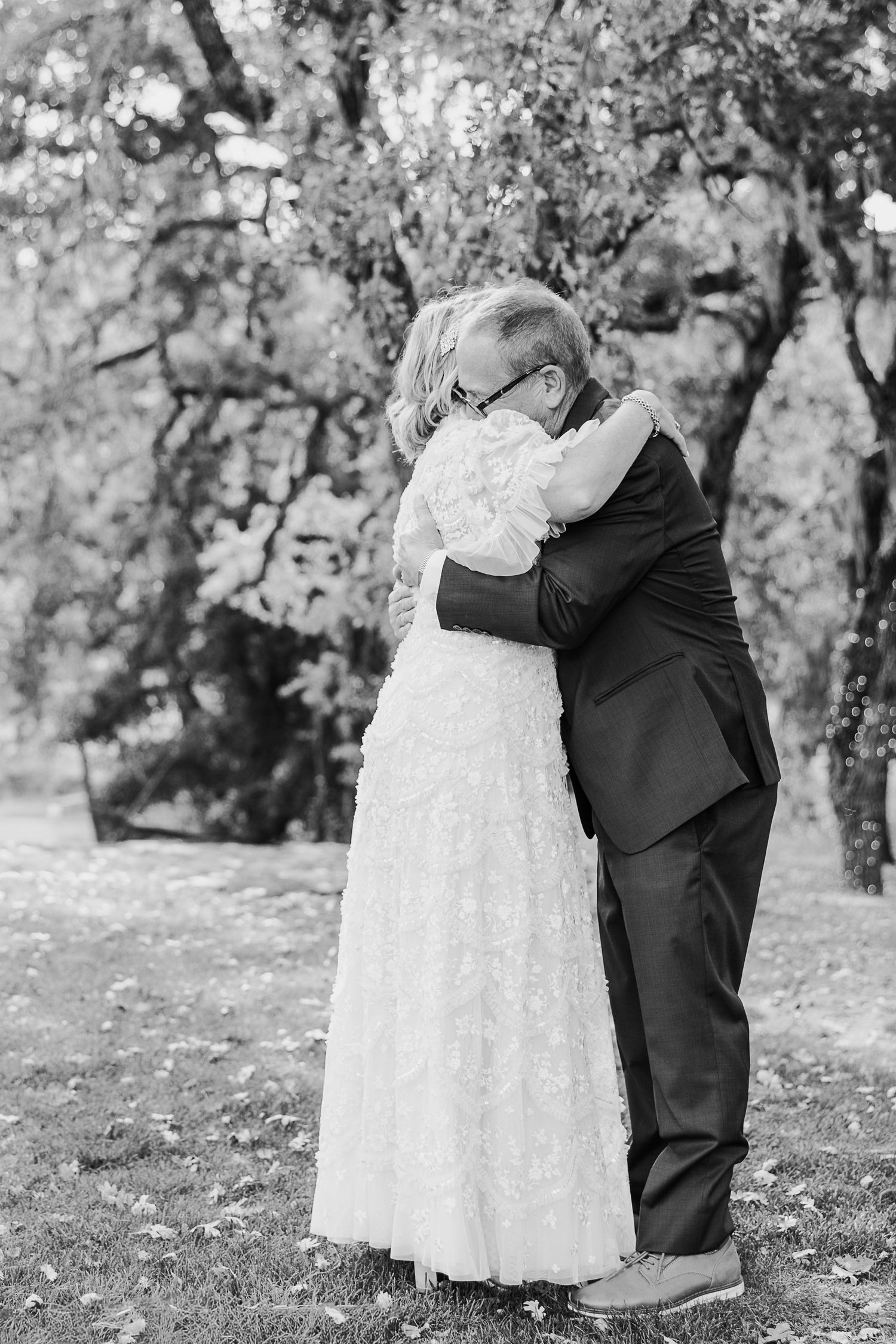 Black and white wedding photos showing tender moments between newlyweds in an outdoor setting.