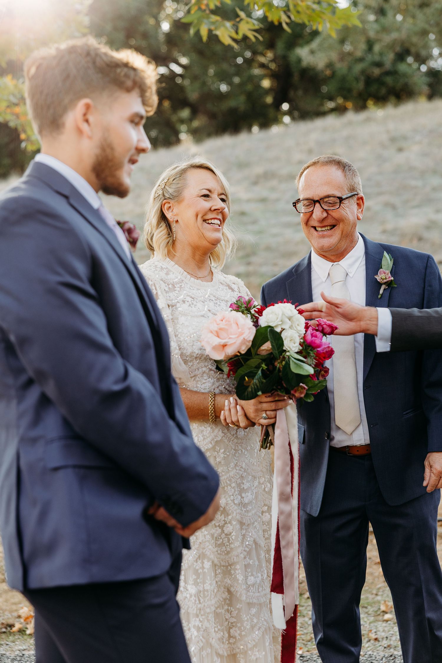 Wedding party sharing joyful moments during an outdoor autumn celebration.