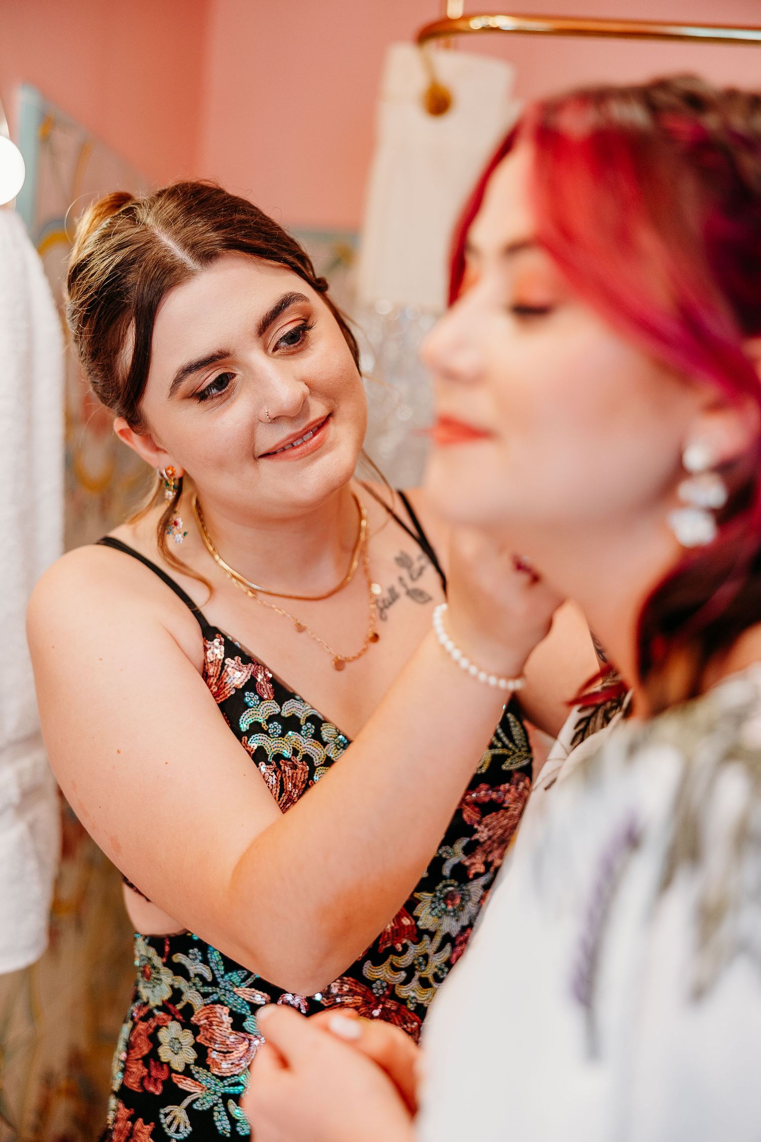 Two people in floral attire sharing an intimate moment during wedding preparations.