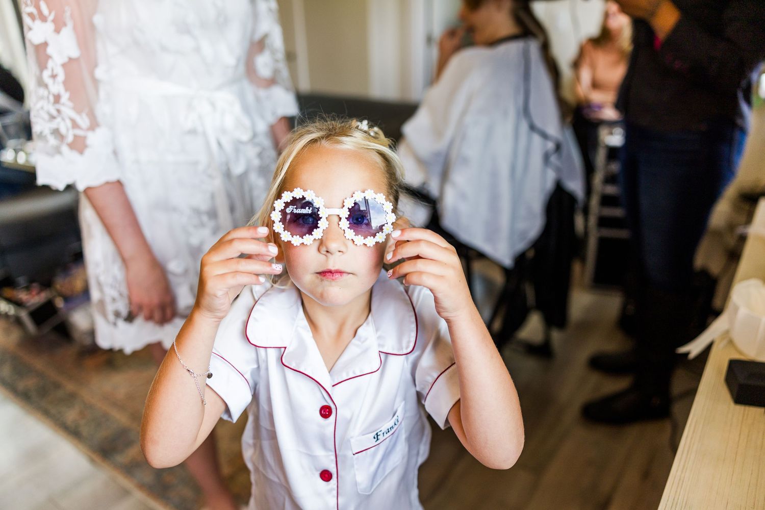 Someone trying on decorative sunglasses during wedding preparations.