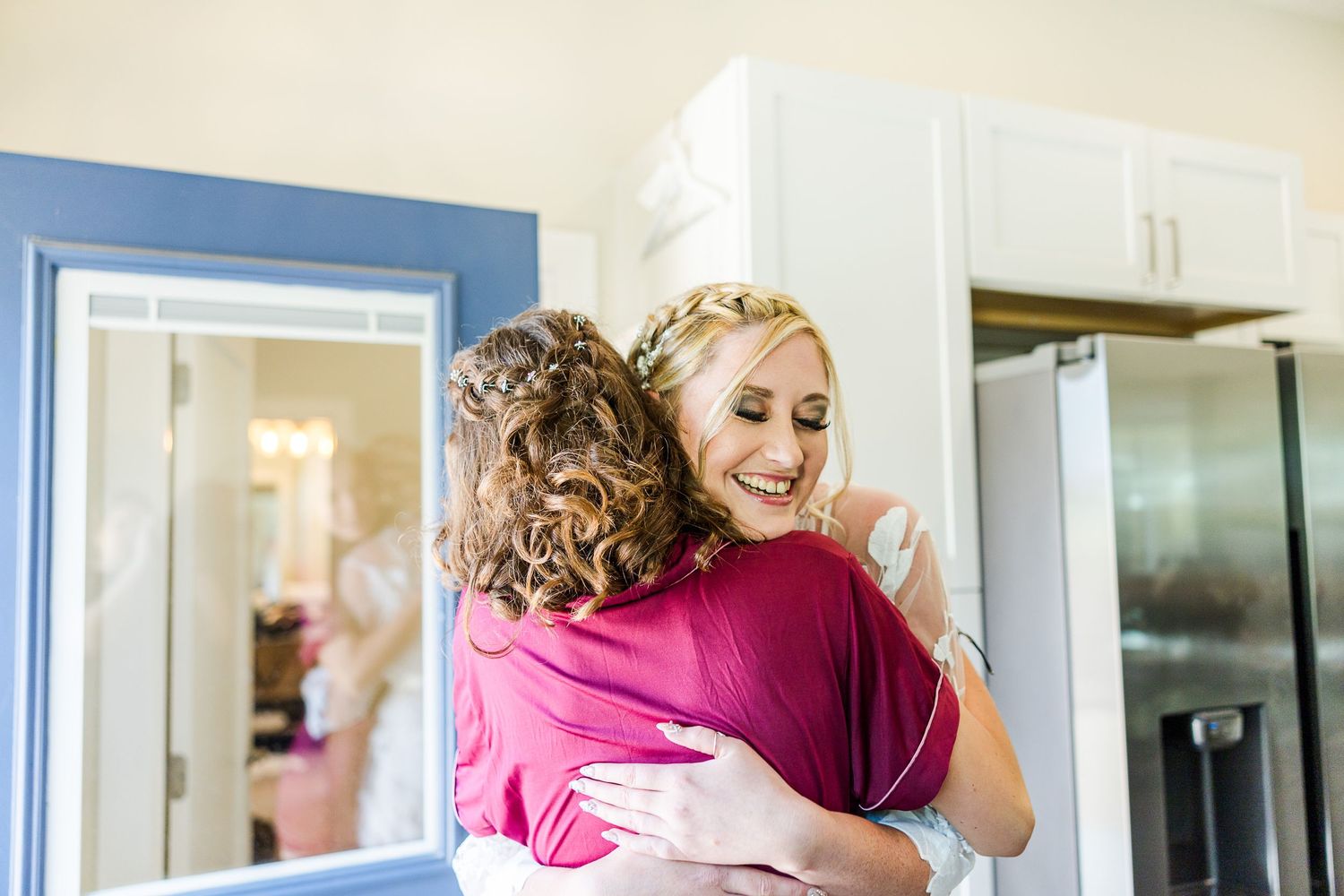 Two people share an emotional embrace during wedding preparations.