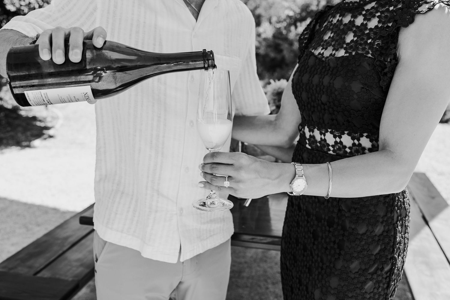 Black and white candid photograph of guests mingling at an outdoor event.