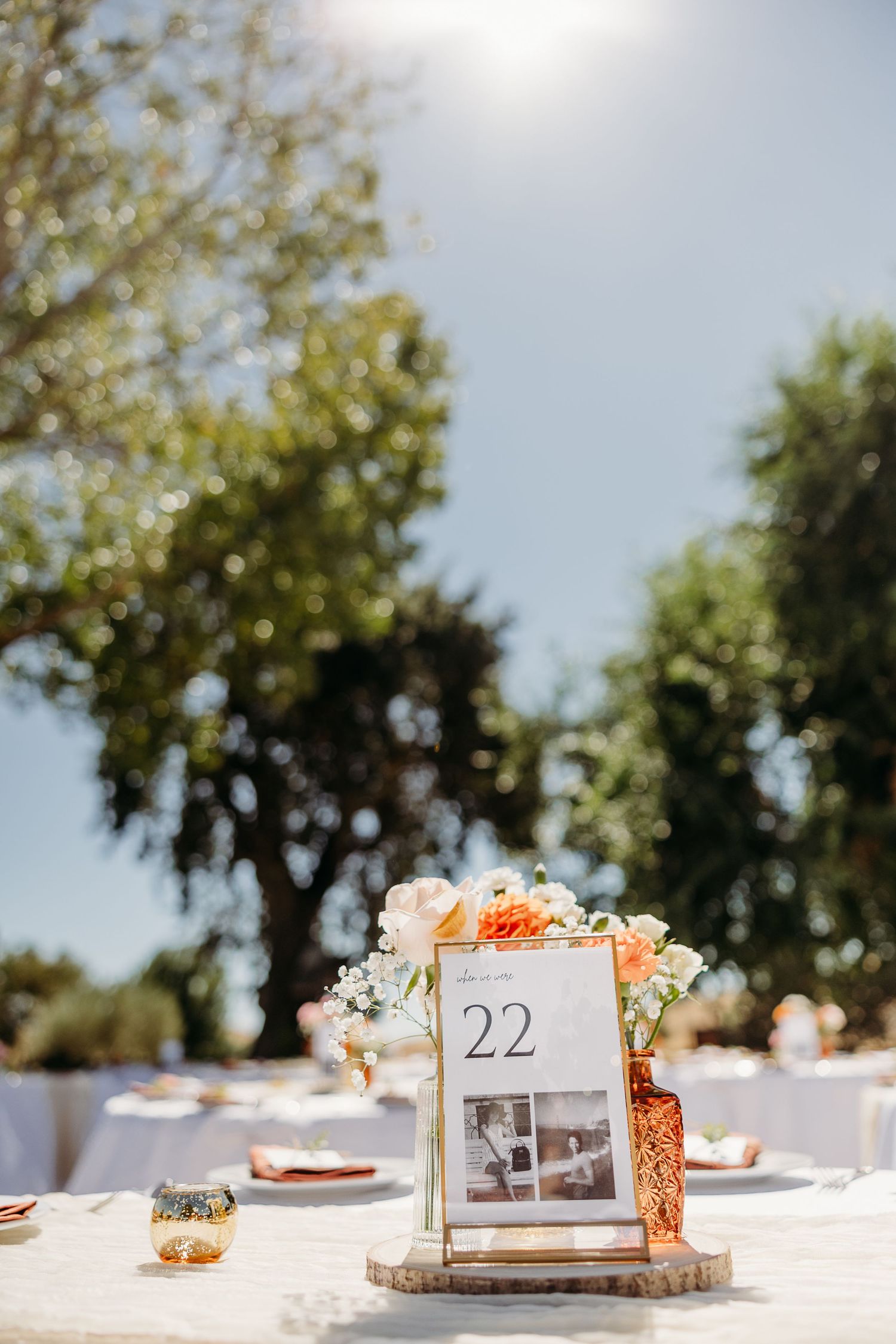 Table number 22 display with floral accents and wood slice base in outdoor setting.