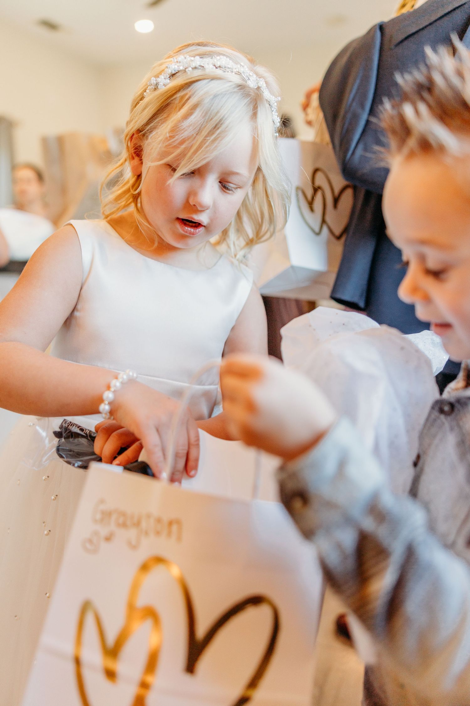 Children writing and drawing on paper during a creative activity at a table.