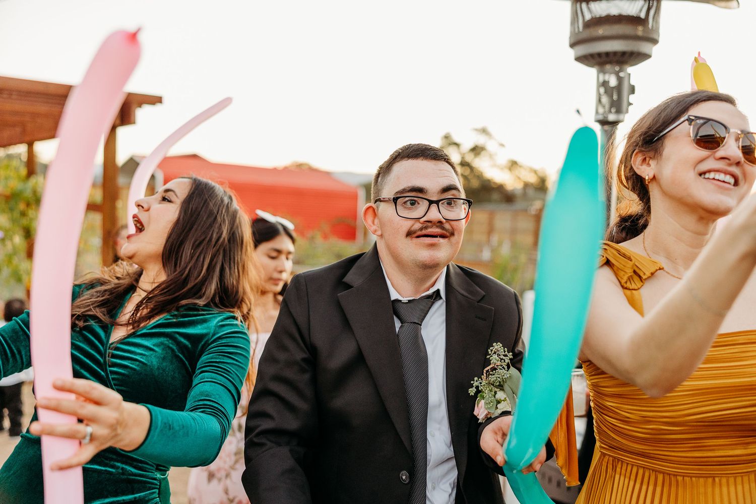 Wedding guests celebrating and dancing joyfully at an outdoor reception.
