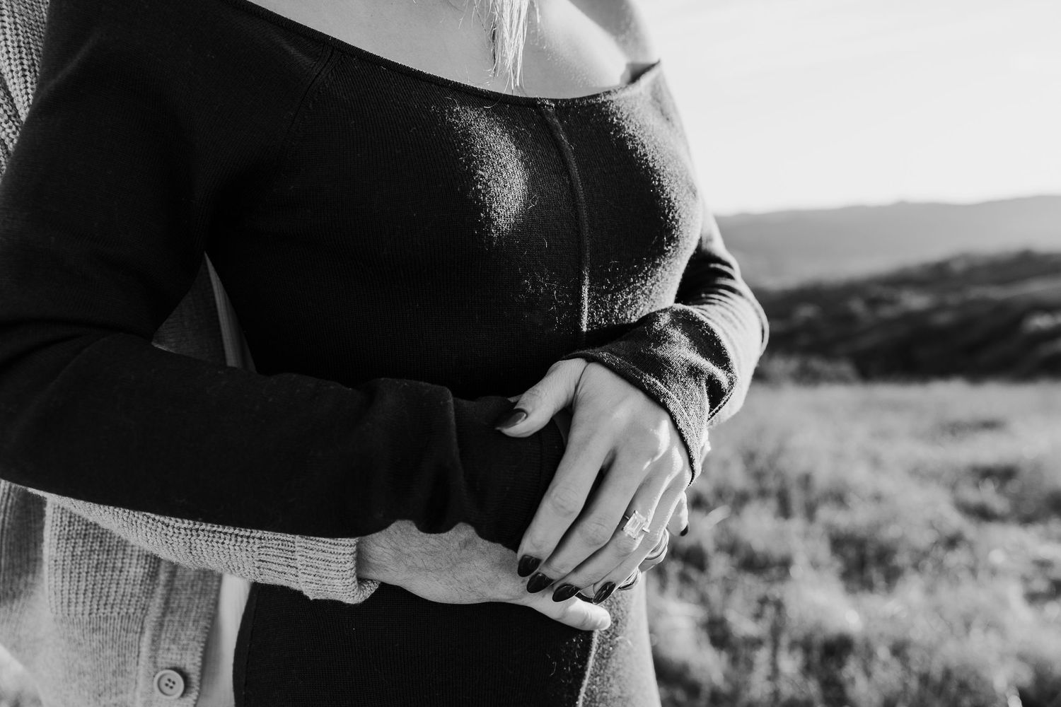 Black and white close-up photo of a couple sharing an intimate moment outdoors.