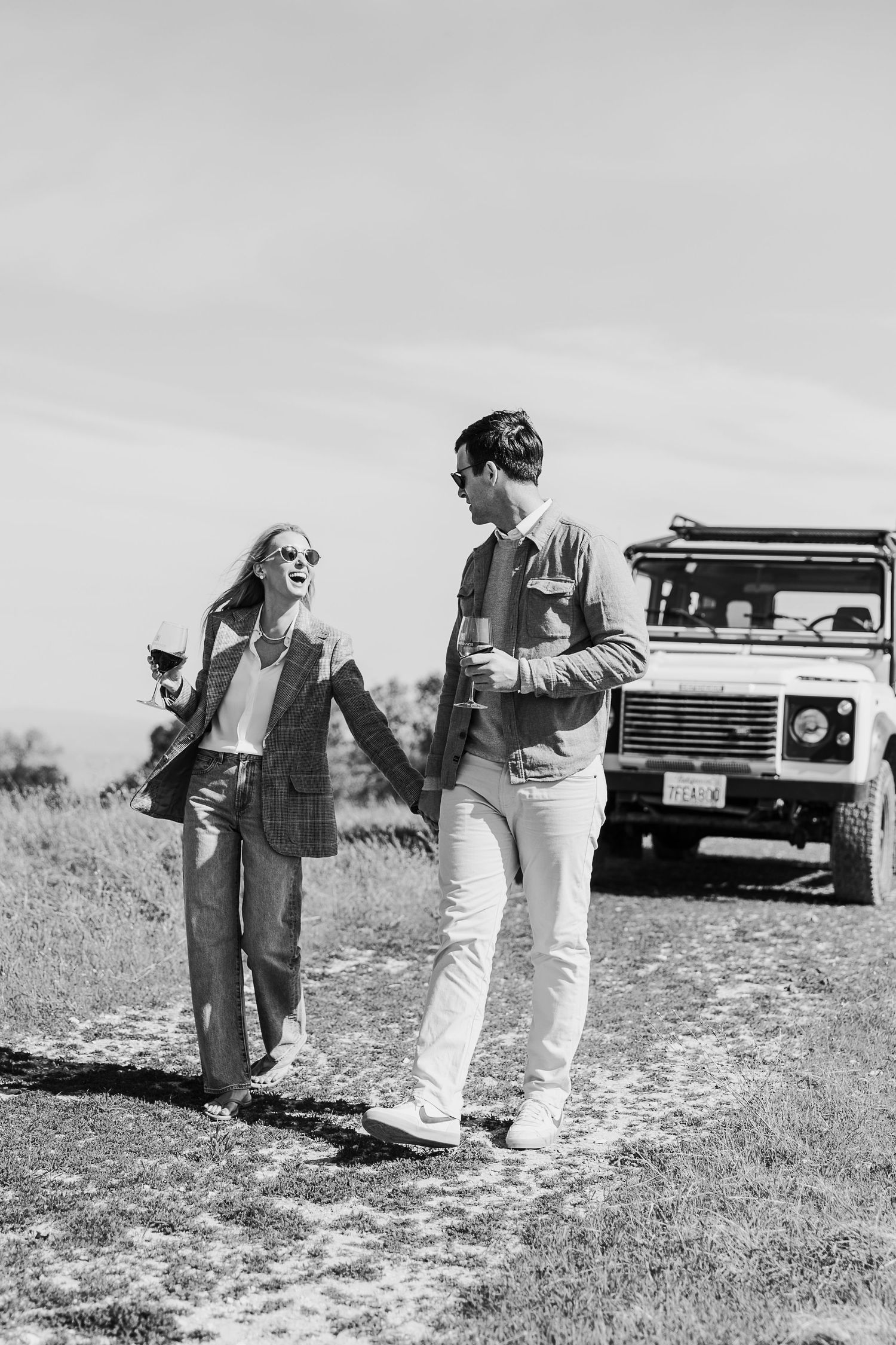 Vintage black and white photos of people standing in a field with a Land Rover vehicle visible in the background.