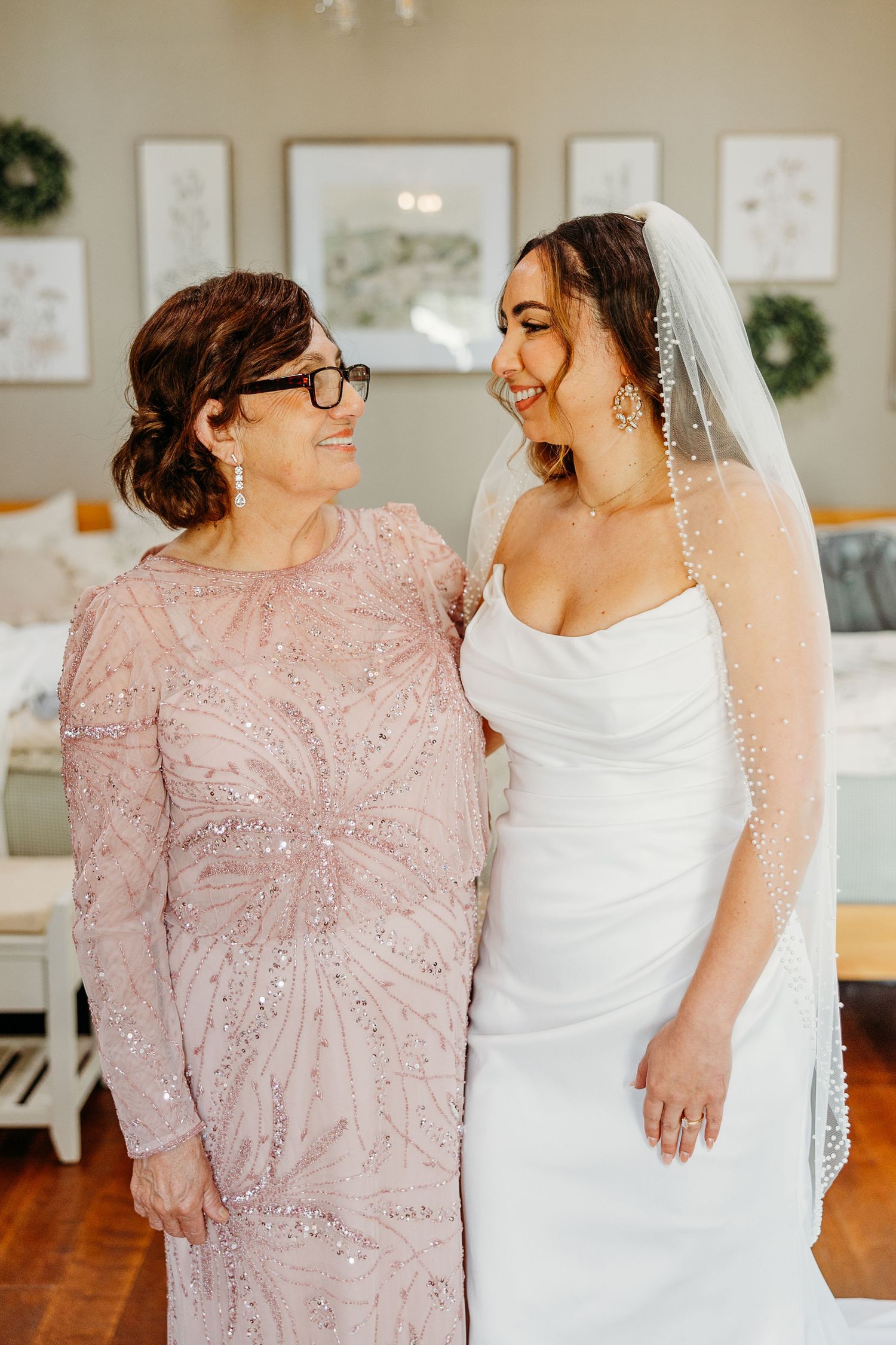 Wedding photos showing a bride in white and companion in pink lace sharing joyful moments together.