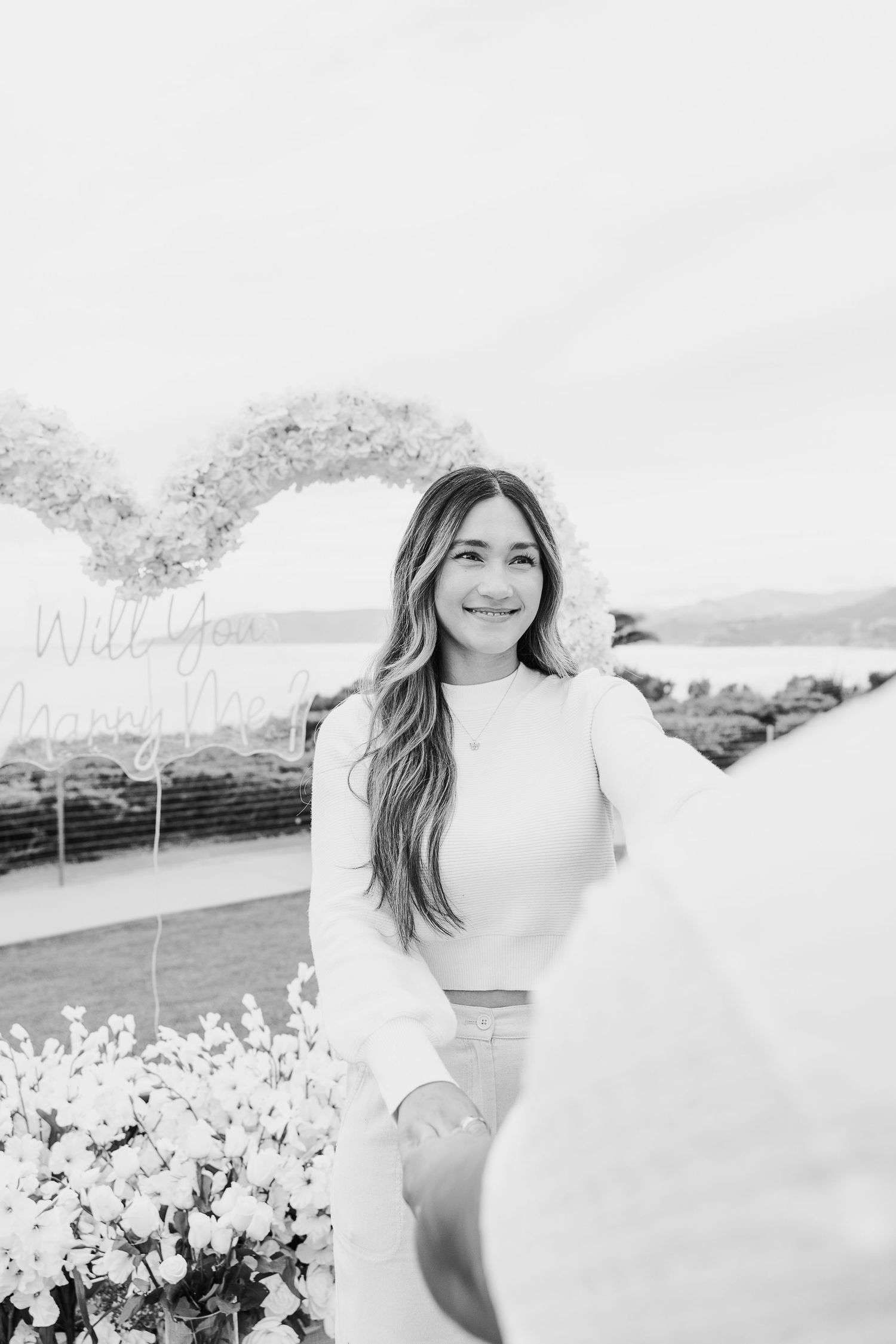 Black and white photos show joyful moments in a garden with white flowers and mountains in the background.