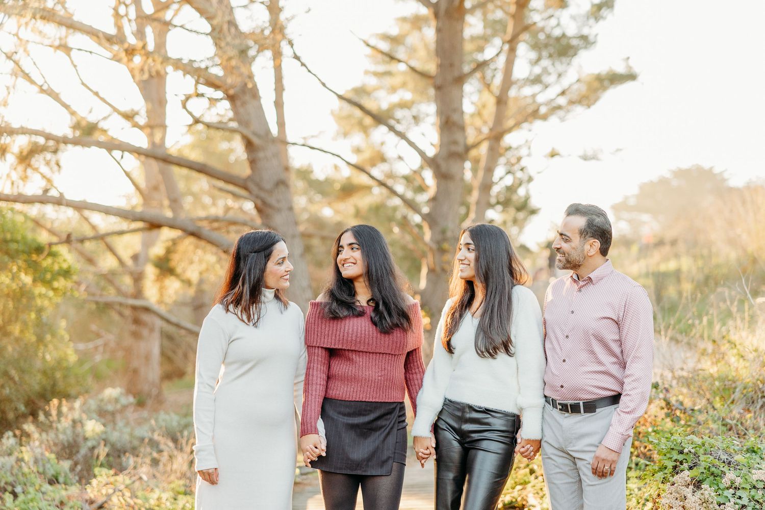 Group photo shoot of friends or family members in casual attire against autumn trees.