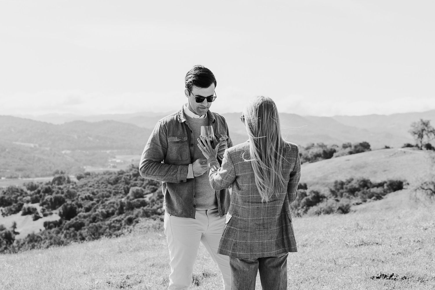 A black and white photo sequence shows a couple walking together in a scenic outdoor landscape.