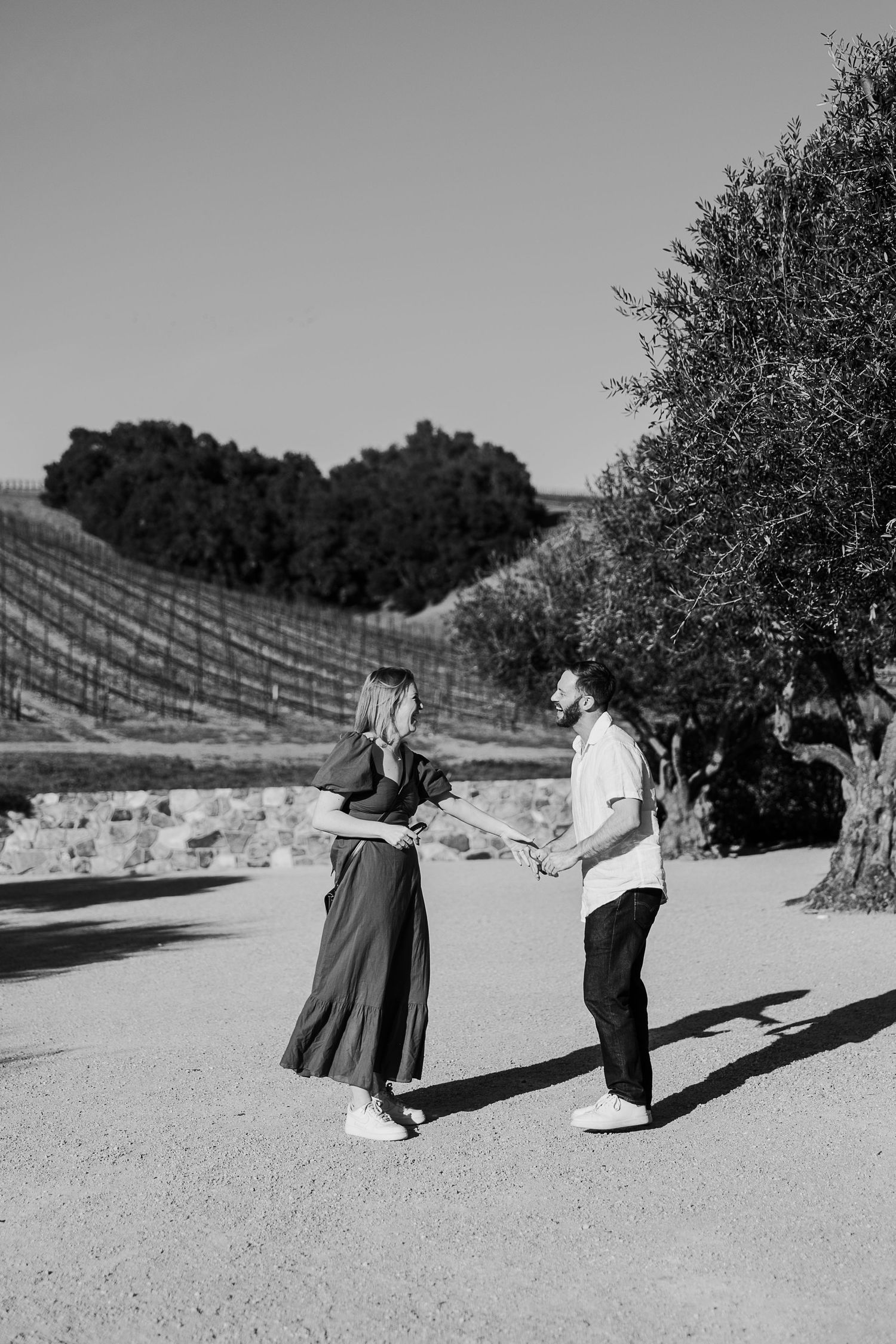 Black and white photo sequence showing two people dancing and spinning in an outdoor vineyard setting.