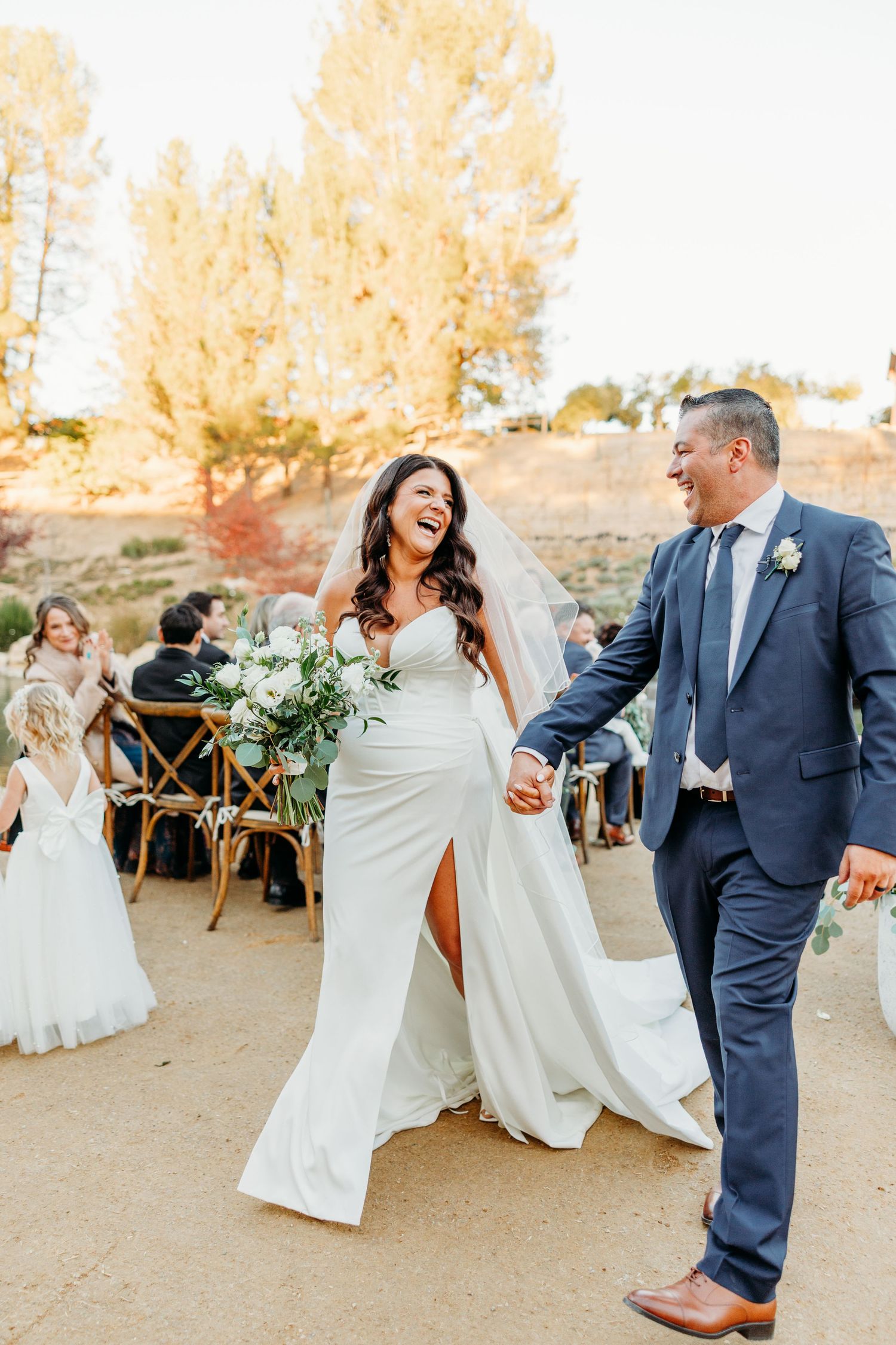 Wedding couple dances and laughs together during sunset at an outdoor desert reception.