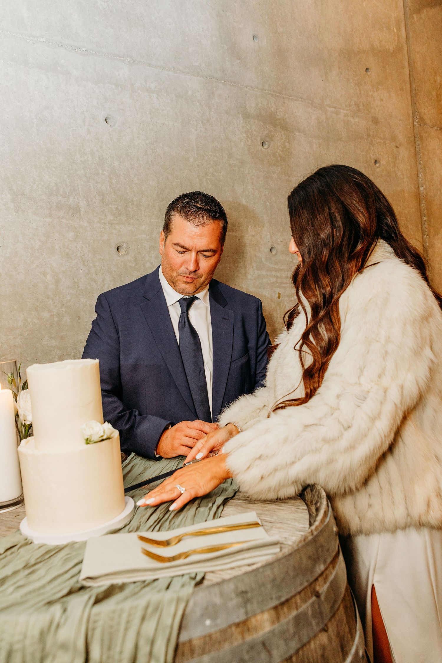 Couple sits at table with white candles during intimate wedding moment.
