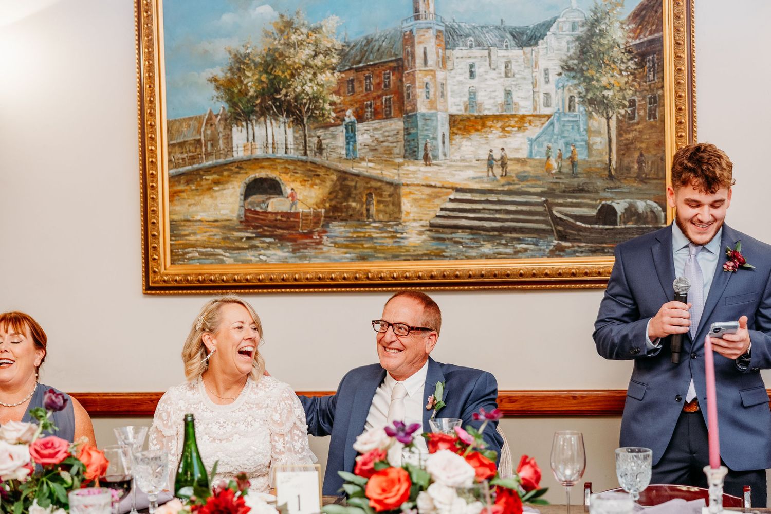 Wedding reception venue decorated with vintage artwork and festive table settings.
