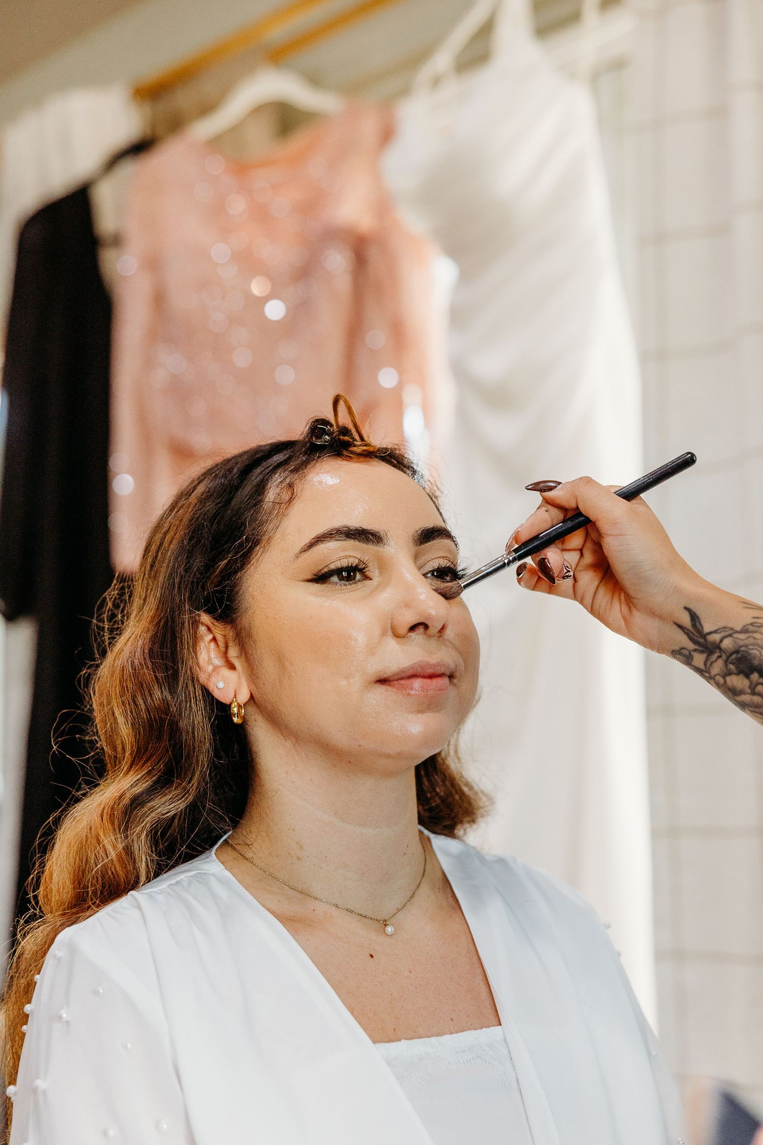 Close-up shots of bridal makeup application in natural lighting.
