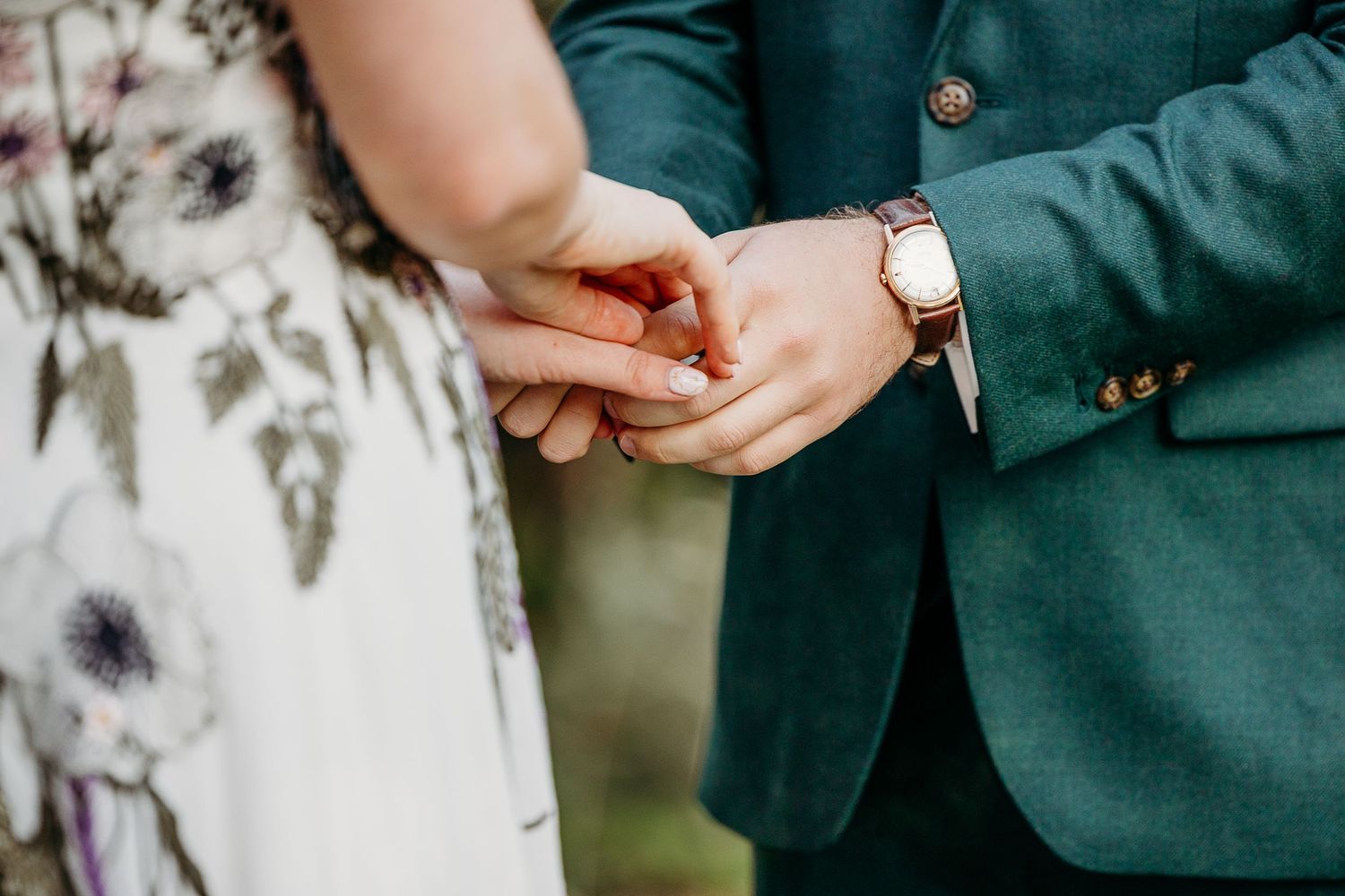 Wedding party members in formal attire stand together during an outdoor autumn celebration.