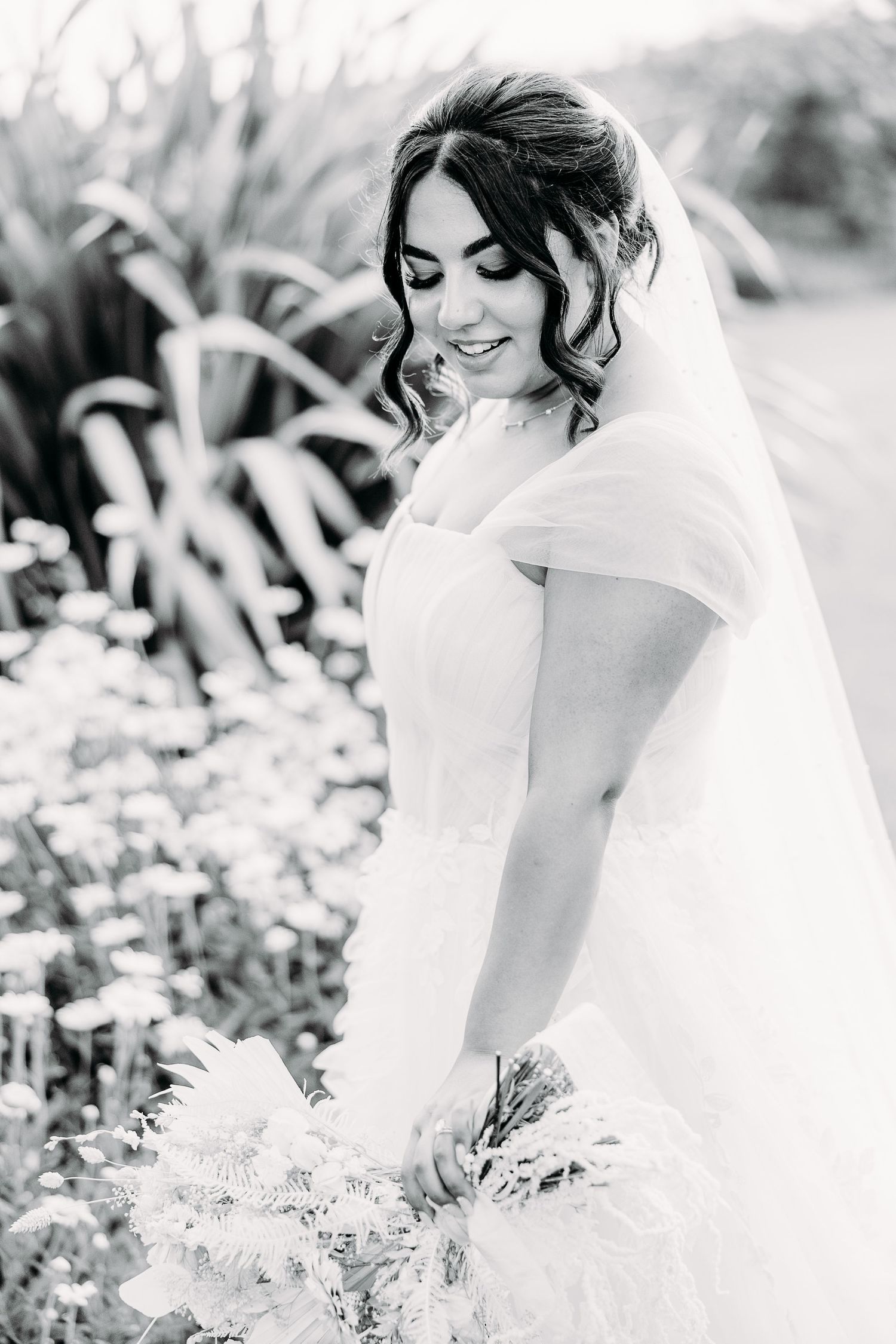 Elegant bridal portrait in black and white with soft natural garden backdrop.