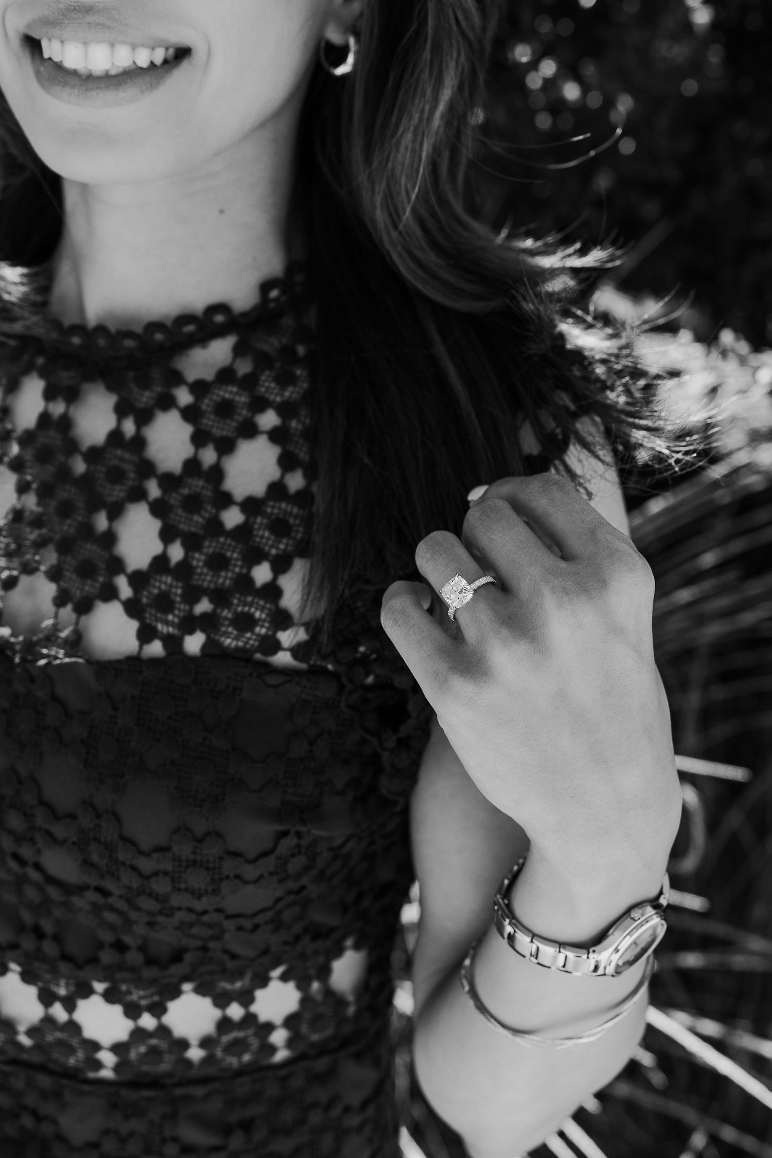 Black and white close-up of delicate lace details and jewelry accessories.
