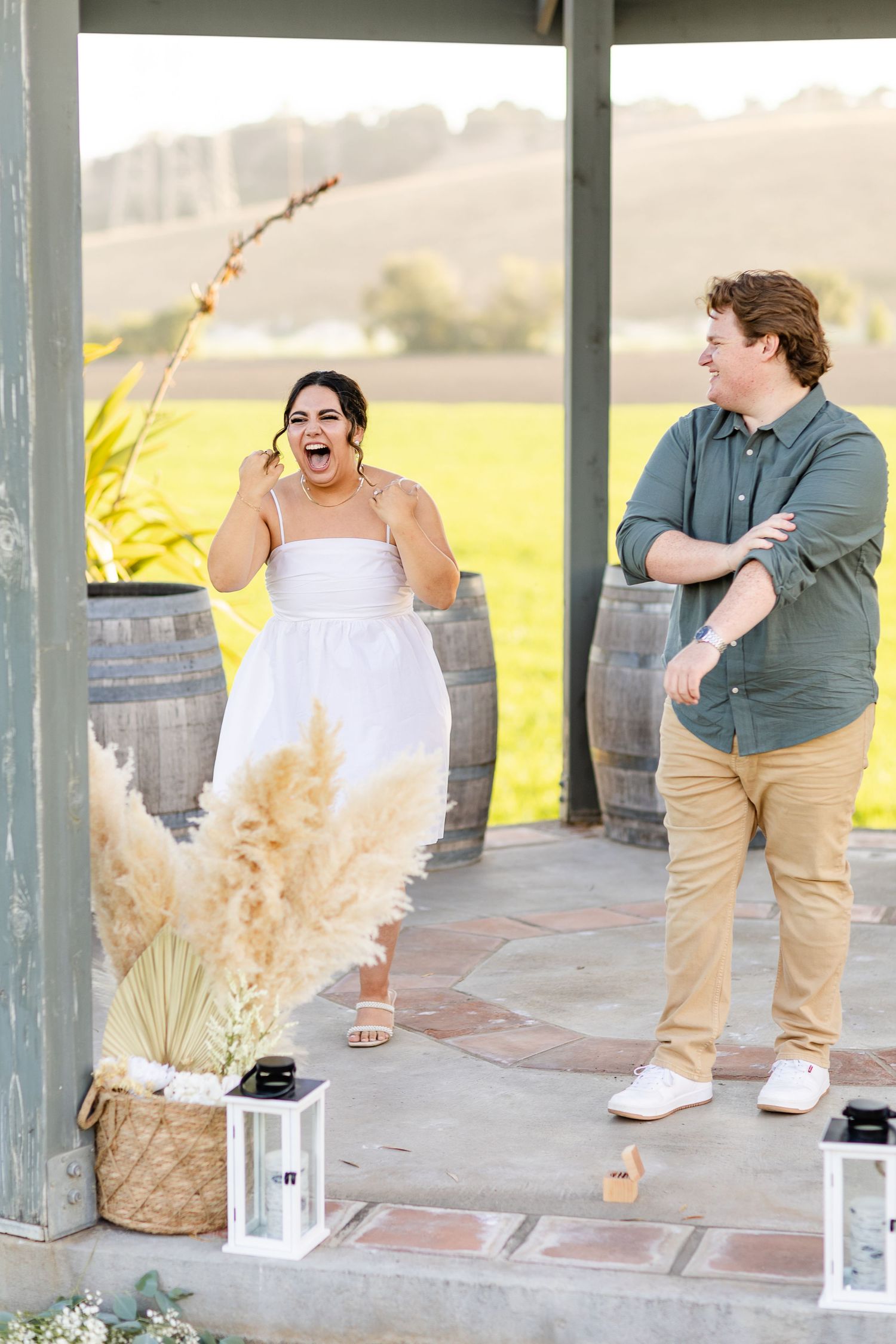 A candid moment of laughter shared between a couple in a decorated outdoor gazebo.