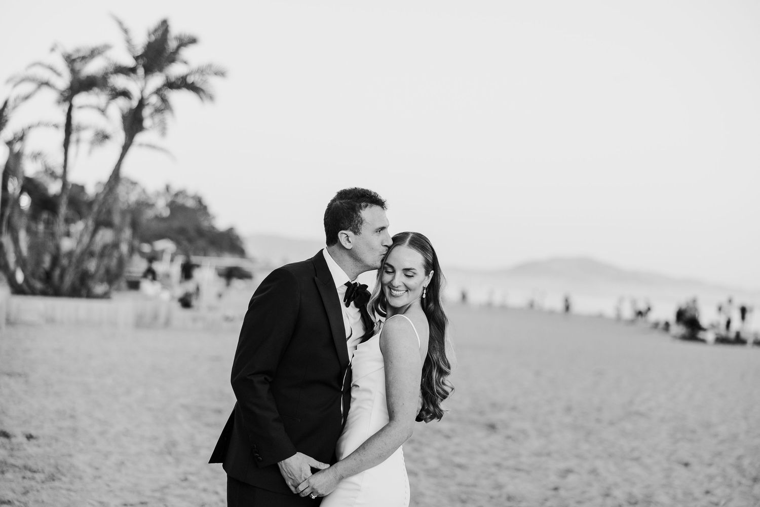 Wedding couple shares intimate moments during an outdoor beach photoshoot.