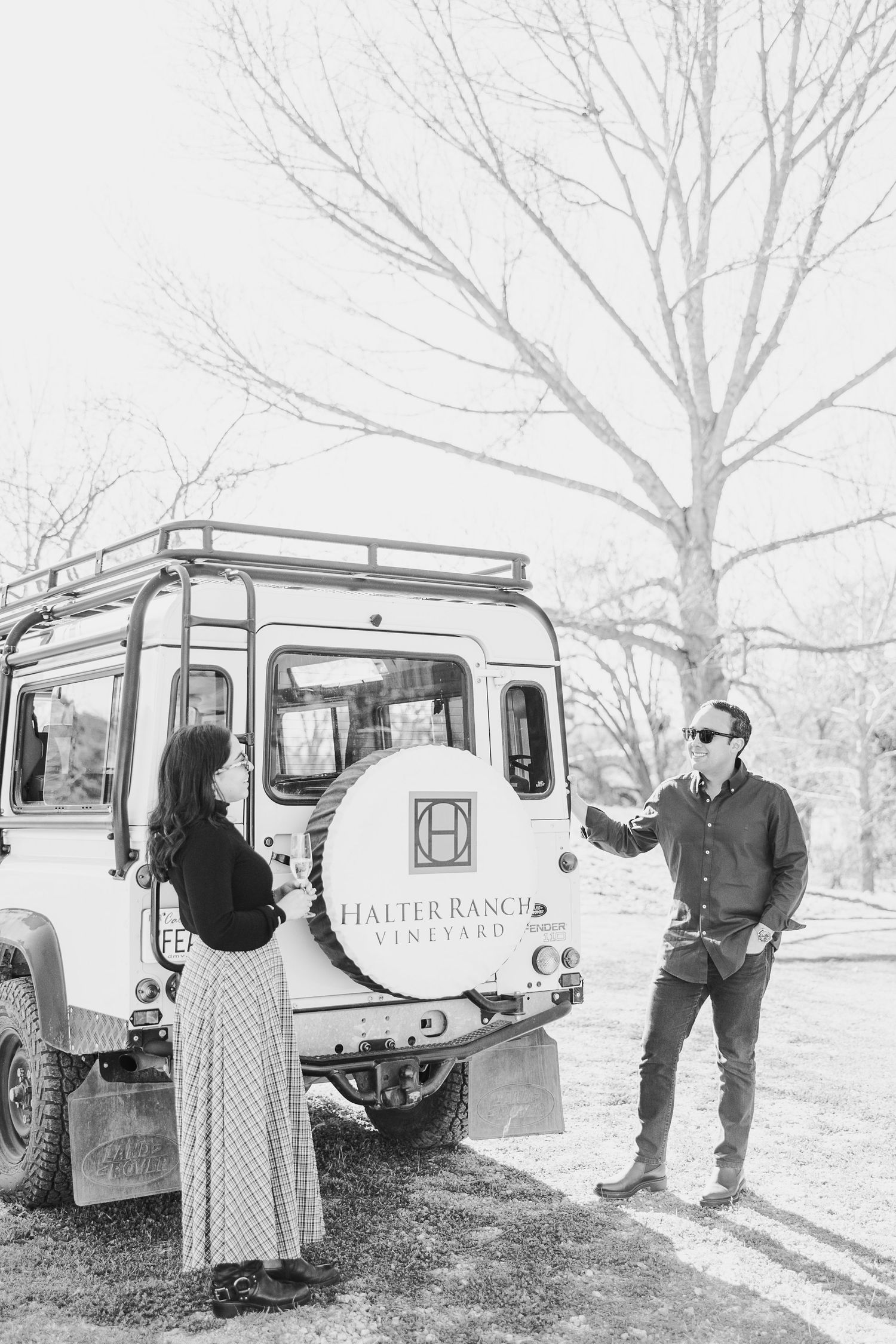 A vintage white Land Rover serves as a backdrop for an outdoor photo session.