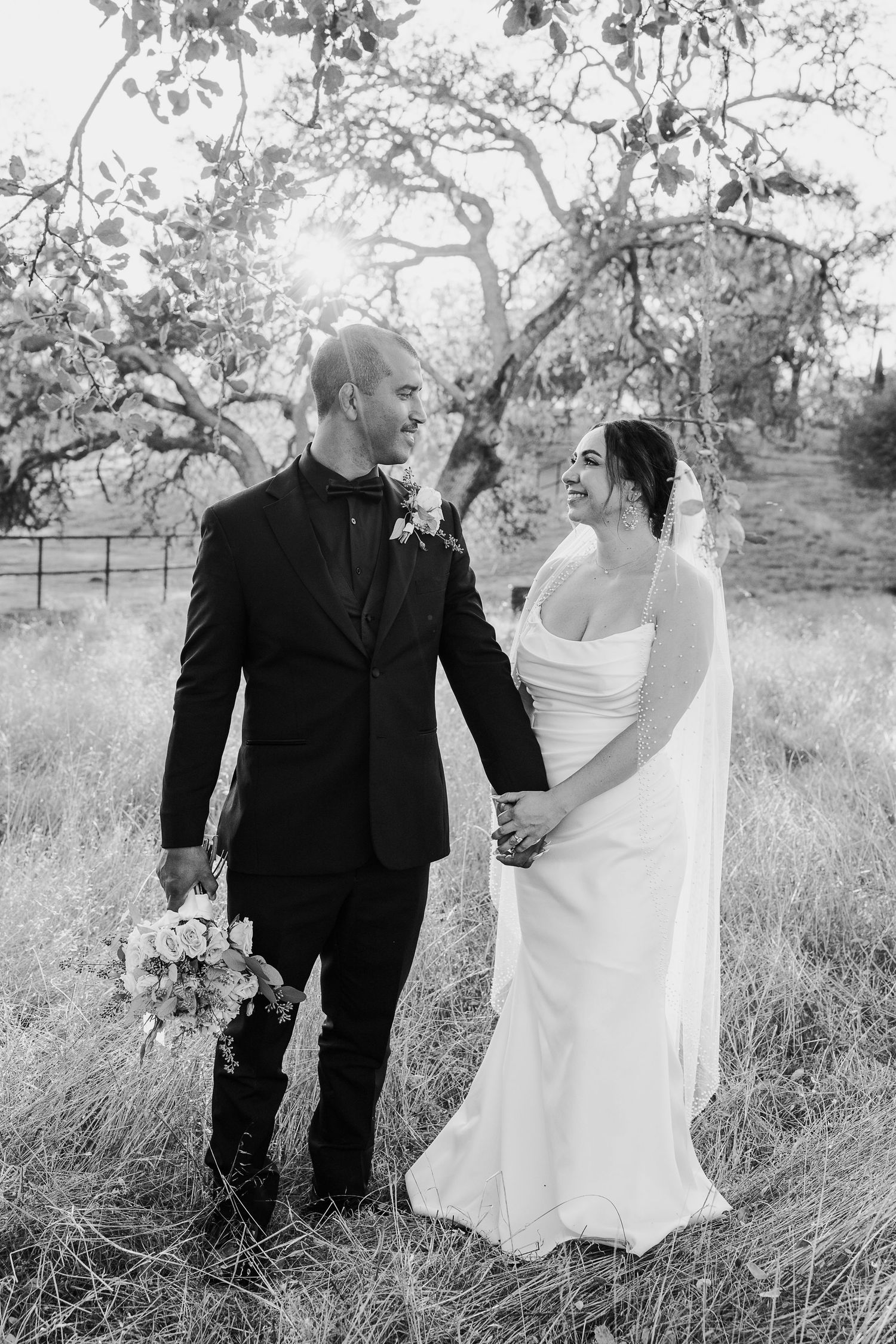 Black and white wedding portraits taken in a rustic field setting.