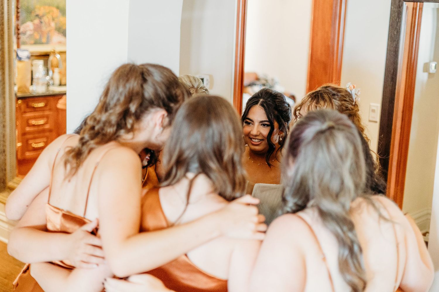 An intimate gathering showing celebration and connection between friends in matching peach-colored attire.