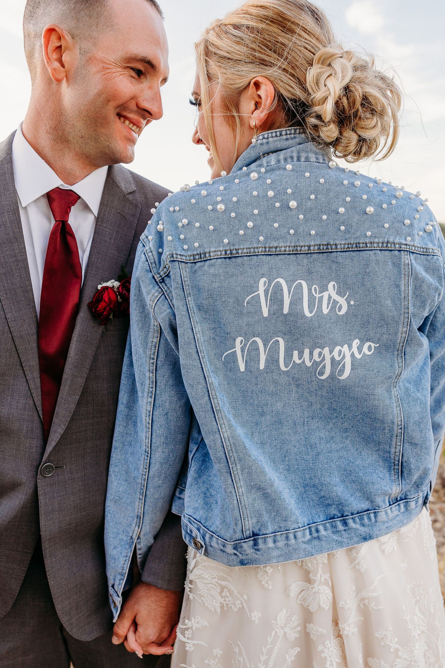 A custom denim jacket showing 'Mrs Muggle' text worn over a wedding dress.