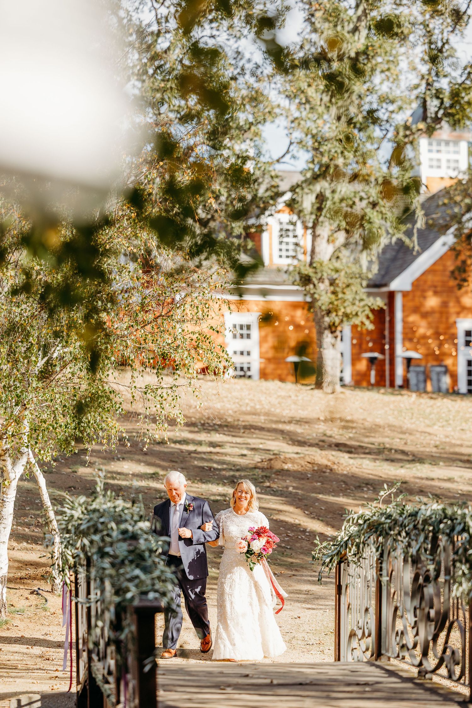 Autumn wedding venue with red brick buildings and trees in golden light.