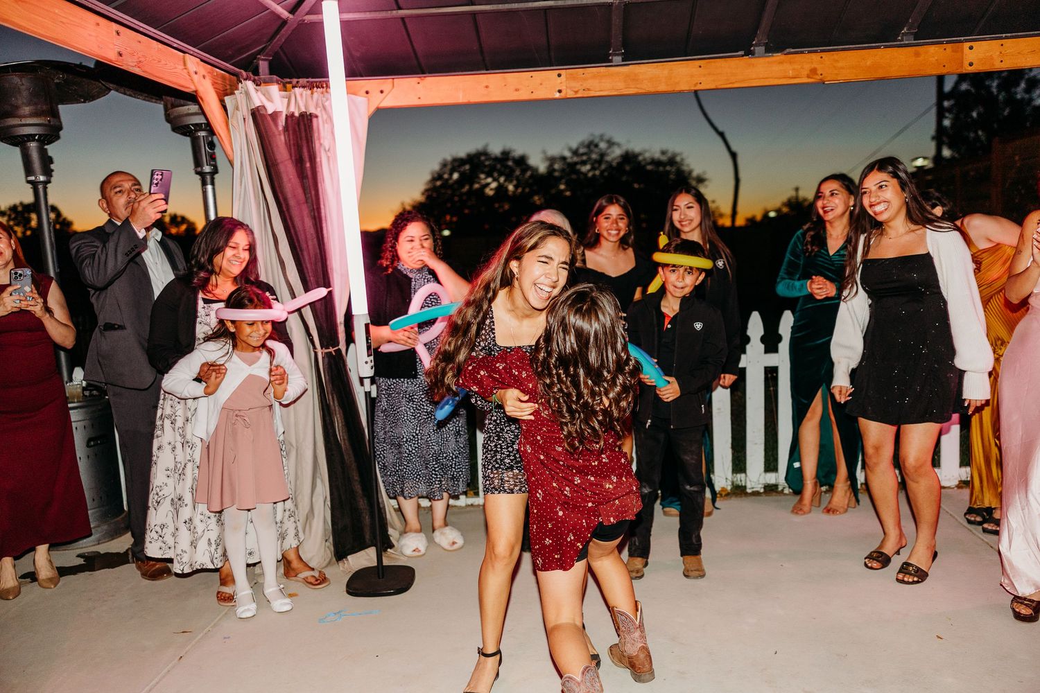 People dancing and celebrating at a lively indoor party with colorful lighting.