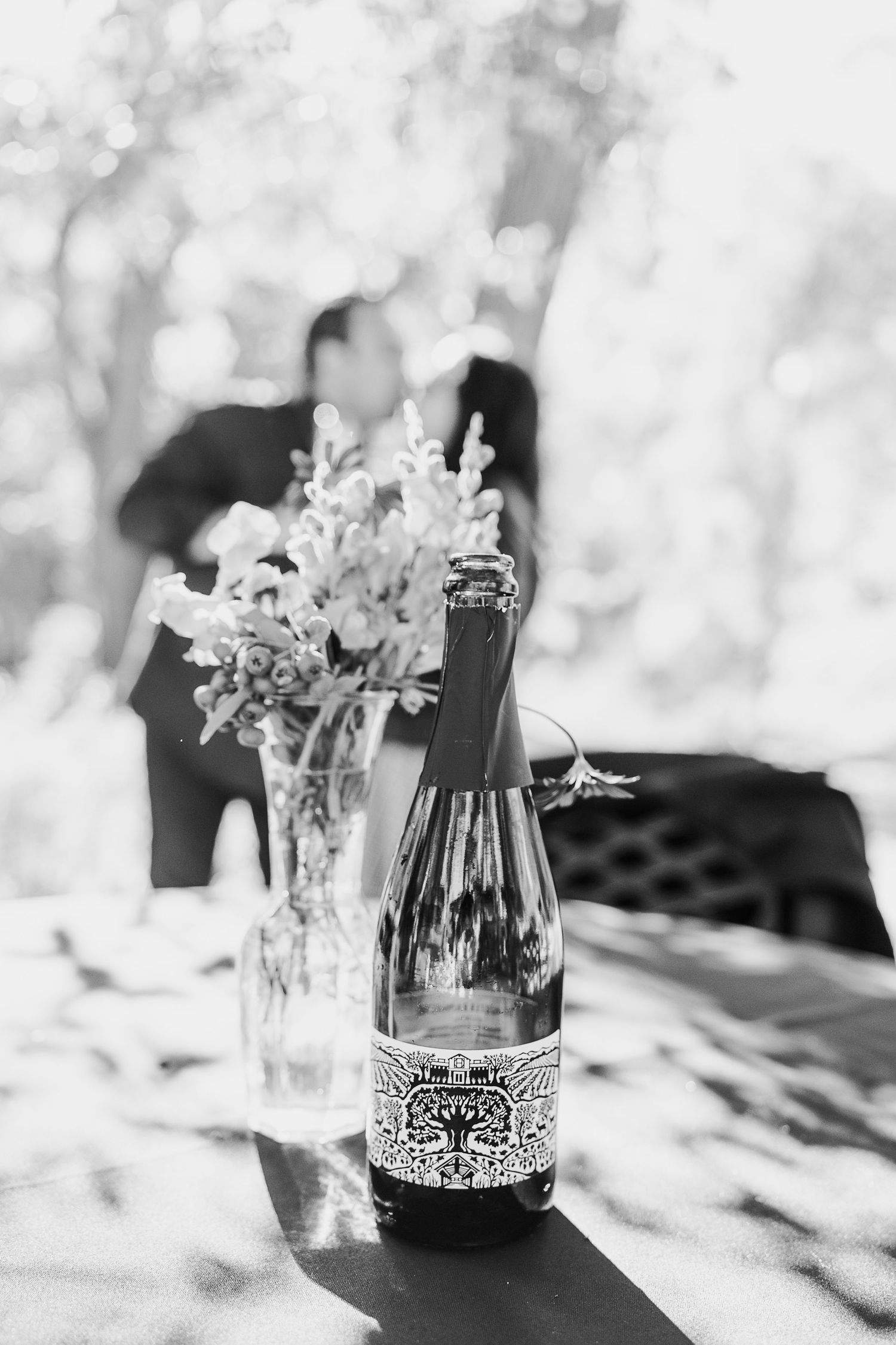 Glass bottles and vases with delicate decorative details arranged on a light surface with soft shadows.