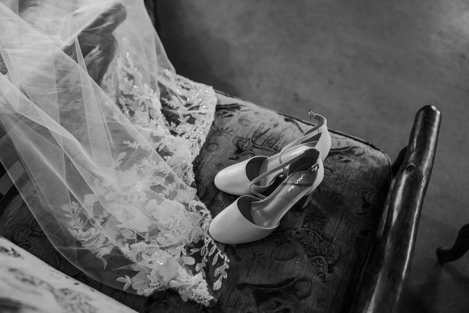 Black and white wedding photography sequence shows bride's dress details and getting ready moments.