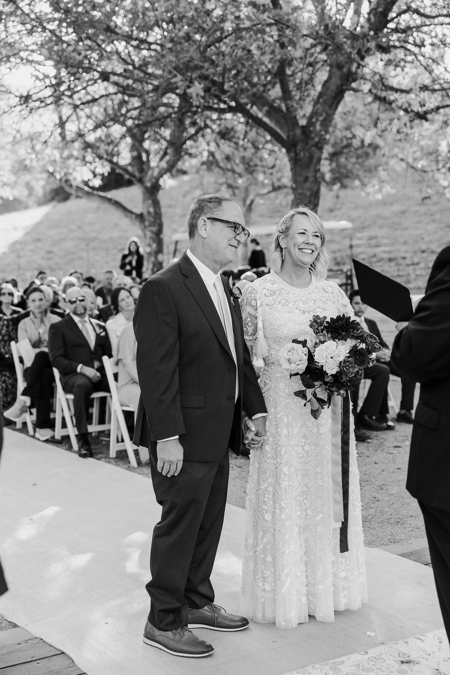 Wedding celebration candid moments captured outdoors under autumn trees.