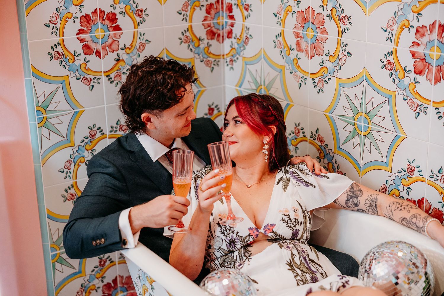 Wedding celebration captured in a series of candid moments with decorative mirror and pink lighting.