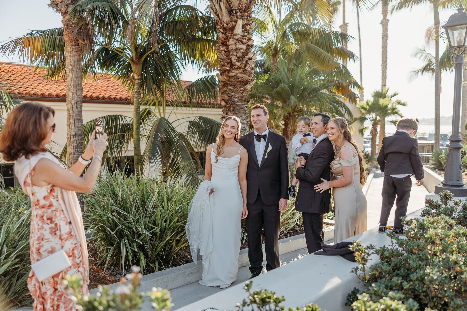 Wedding celebration under palm trees at tropical outdoor venue.