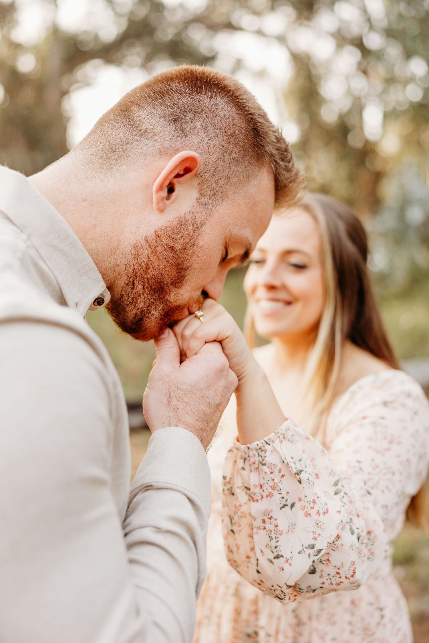Emotional reaction during proposal with couple in natural setting.